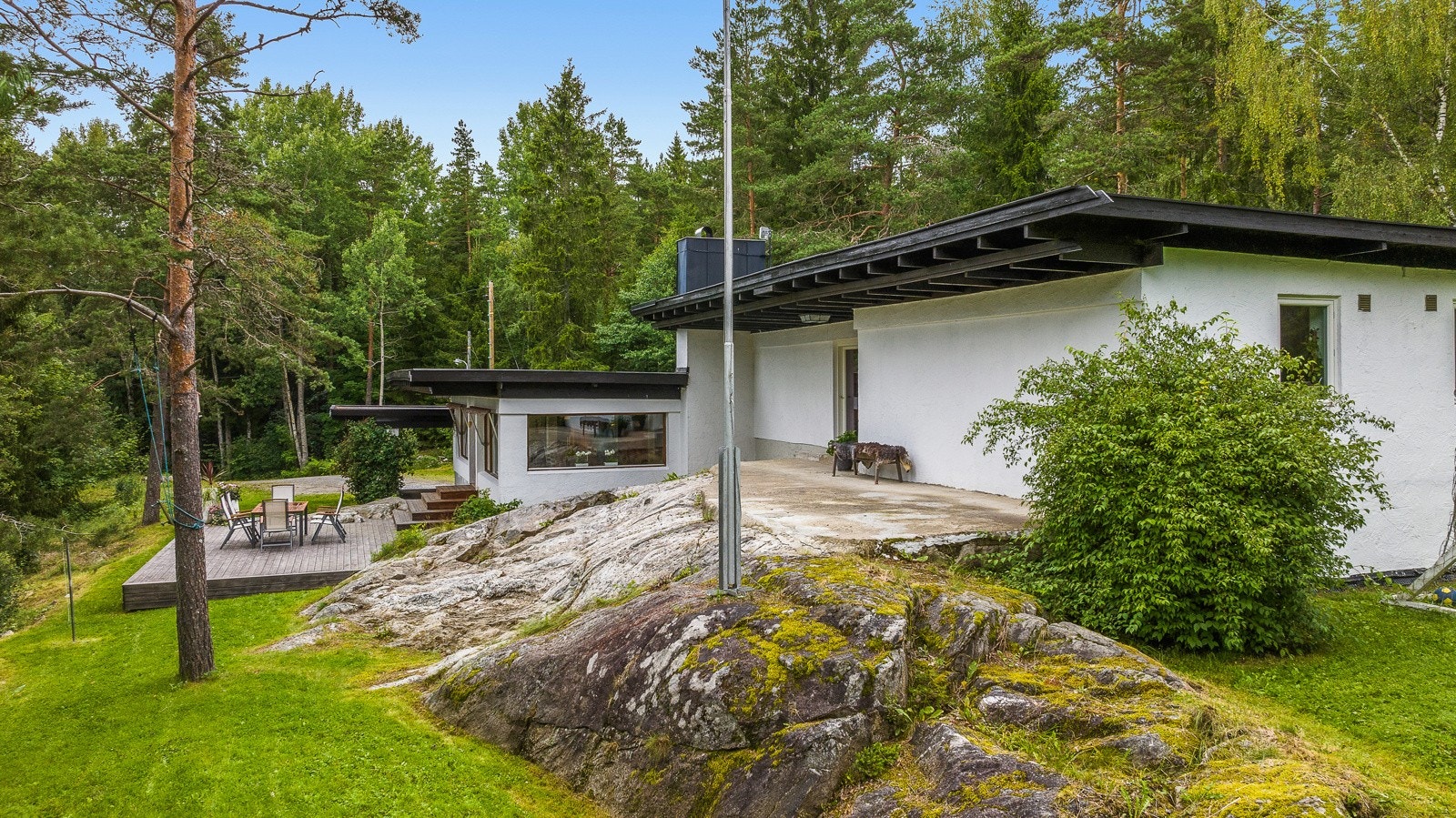 Boligen ligger på en naturskjønn tomt på 2 058 kvm med synlig fjell i dagen, naturlig vegetasjon og trær. Galleribilde