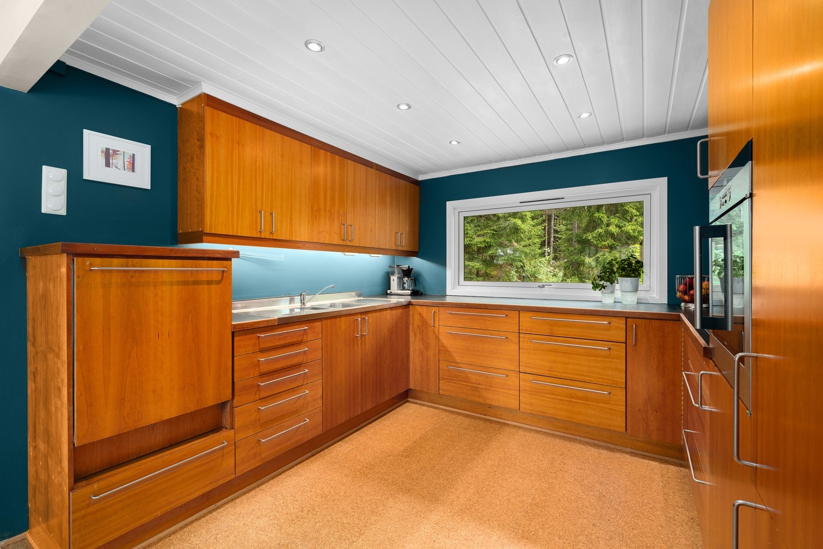 Kjøkkenet har en skreddersydd innredning fra møbelsnekker med integrerte hvitevarer Galleribilde