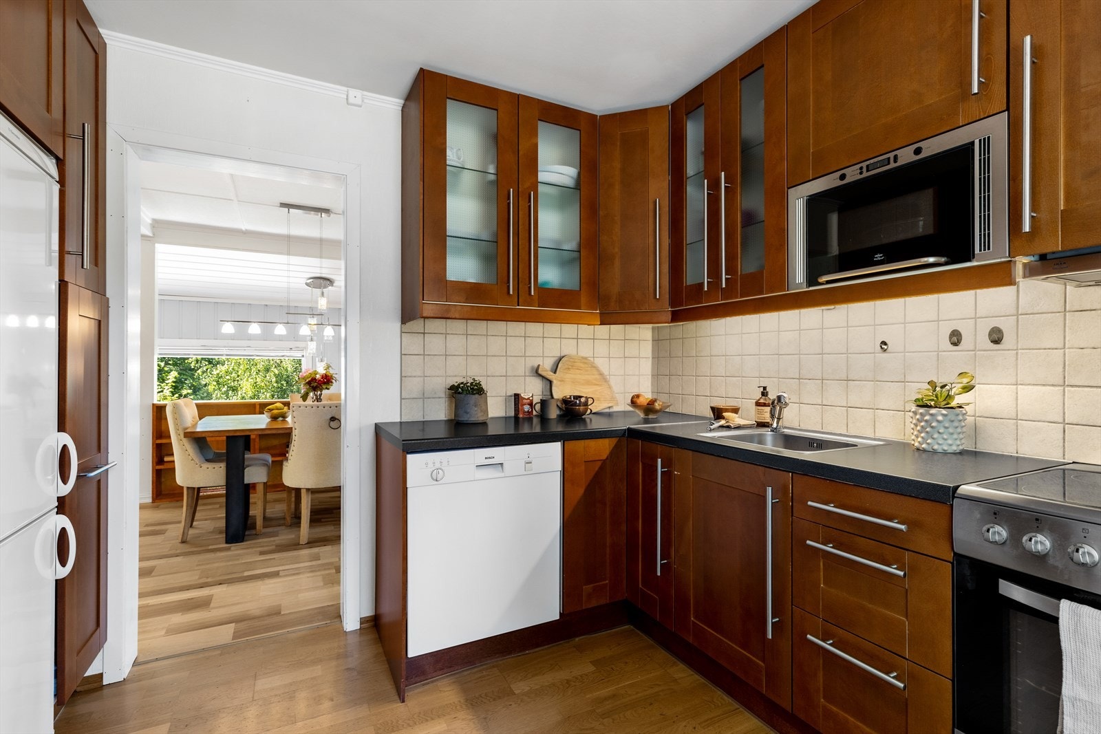 Skuffer og takhøye skap med profilerte finér fronter der enkelte fronter på overskap har omrammet glass. Galleribilde