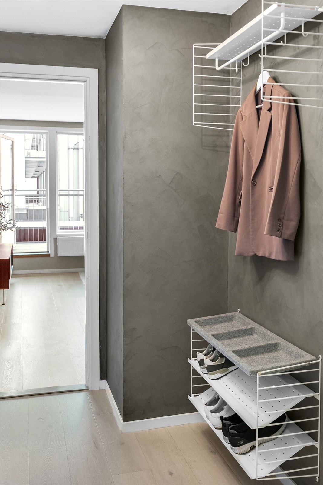 Entréen er malt med kalkmaling og har veggmontert garderobeinnredning. Galleribilde