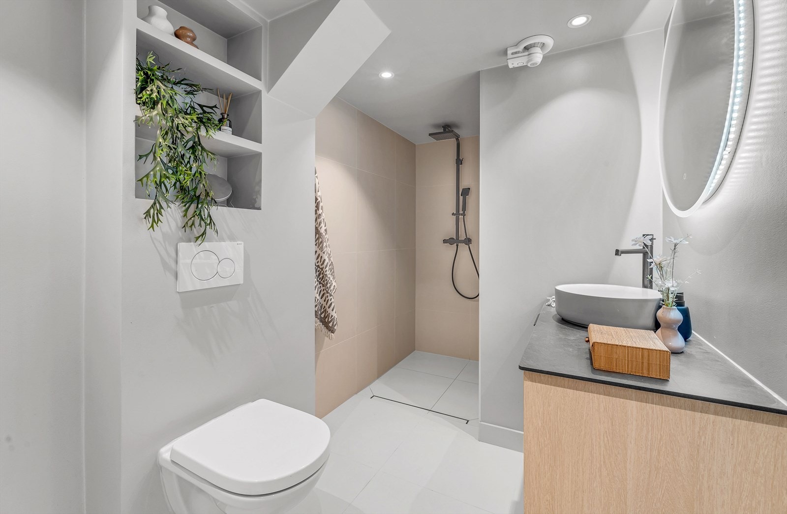 Pent og lyst flislagt baderom fra 2022, med elektriske varmekabler og downlights. Galleribilde