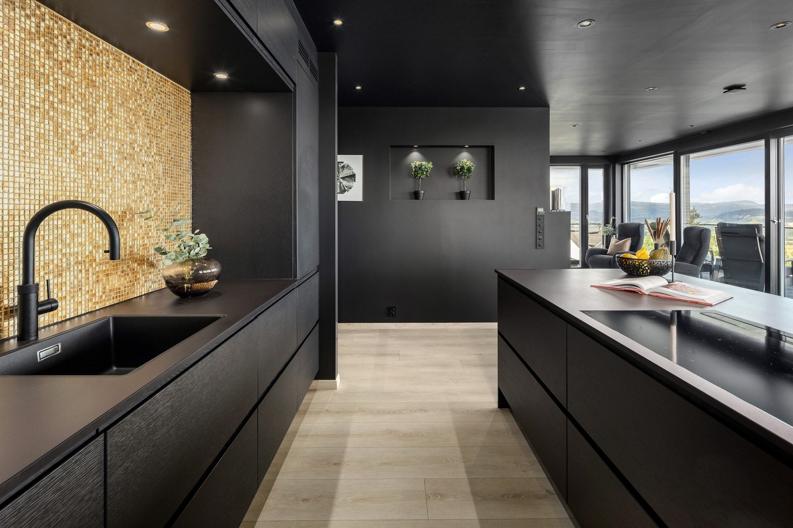 Mosaikkfliser i gull gir en stilig brytning mot det svarte. Dekton benkeplate Galleribilde