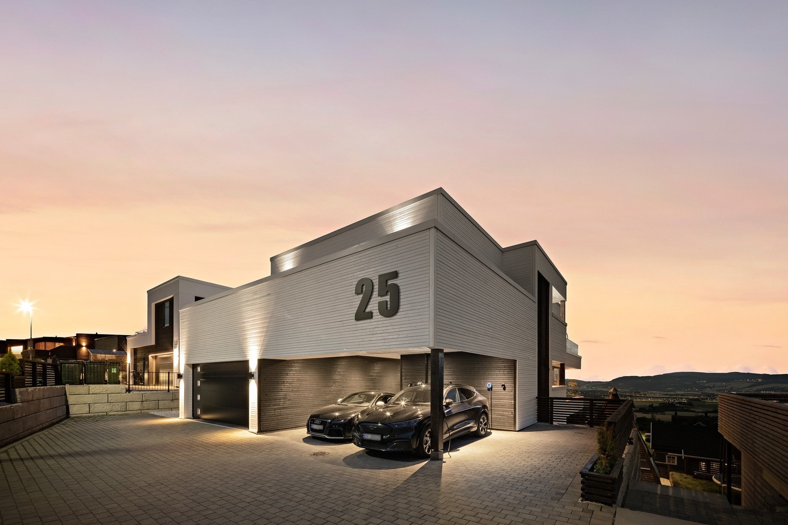 Svært gode parkeringsmuligheter i stor steinlagt gårdsplass. Dobbel garasje og dobbel carport med to elbil-ladere. Adskilt parkering til utleiedelene Galleribilde