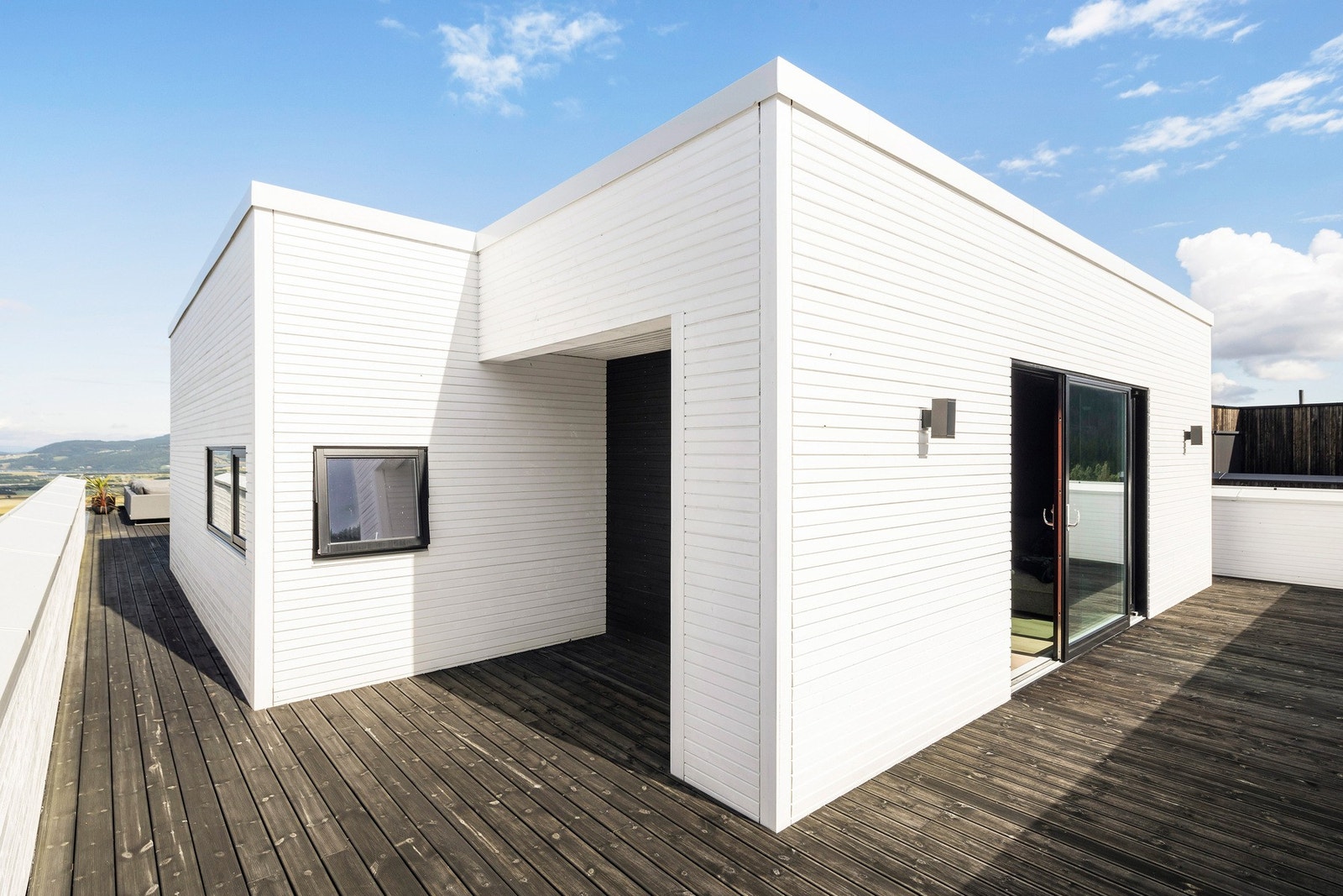 Stor utvendig bod på 7,5 kvm som er perfekt for oppbevaring av hagemøbler og puter. Terrassen strekker seg rundt hele huset slik at du kan nyte alle soltimene Galleribilde