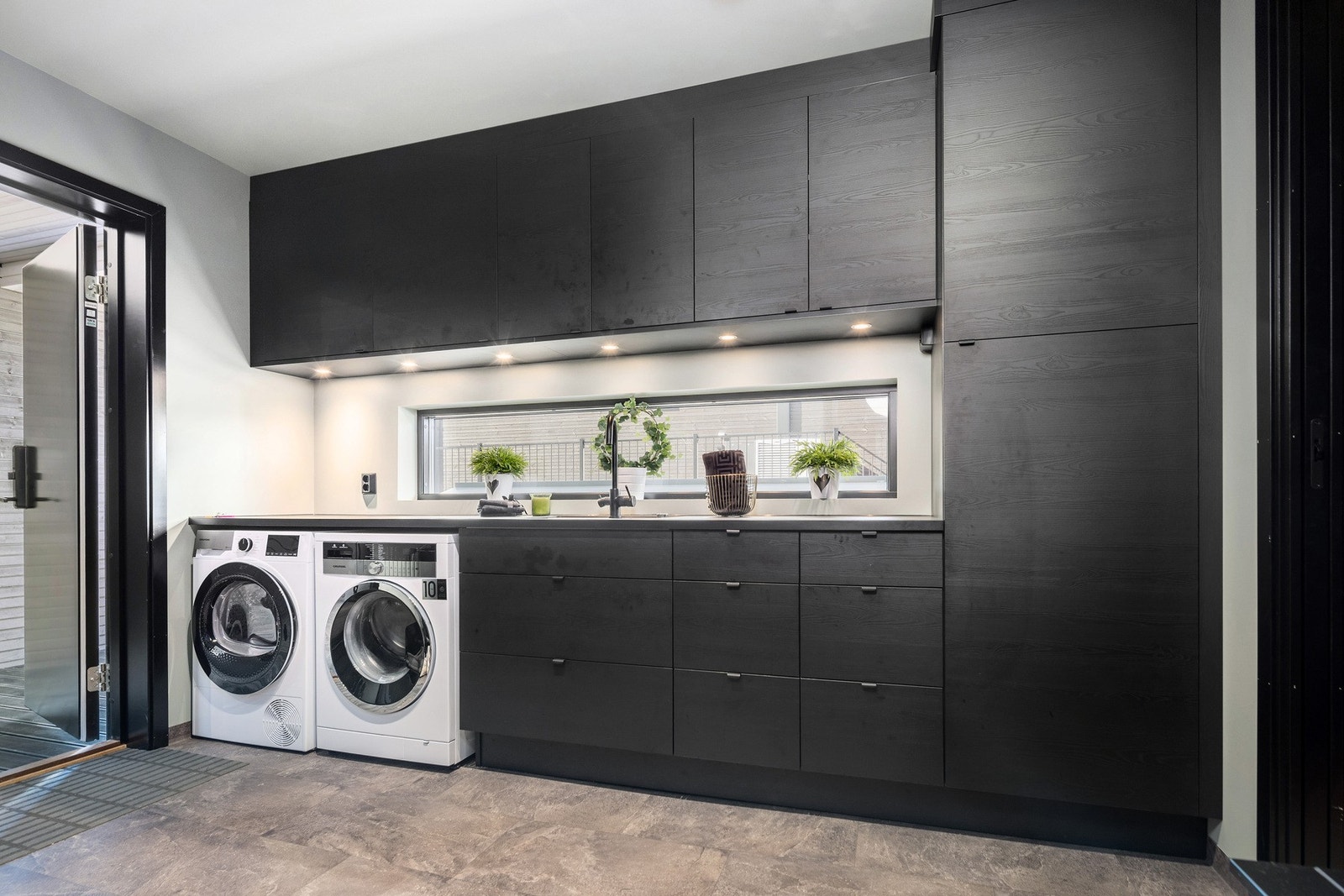 Husets hovedetasje har to innganger. En til gangen og en til et stort vaskerom med innredning Galleribilde