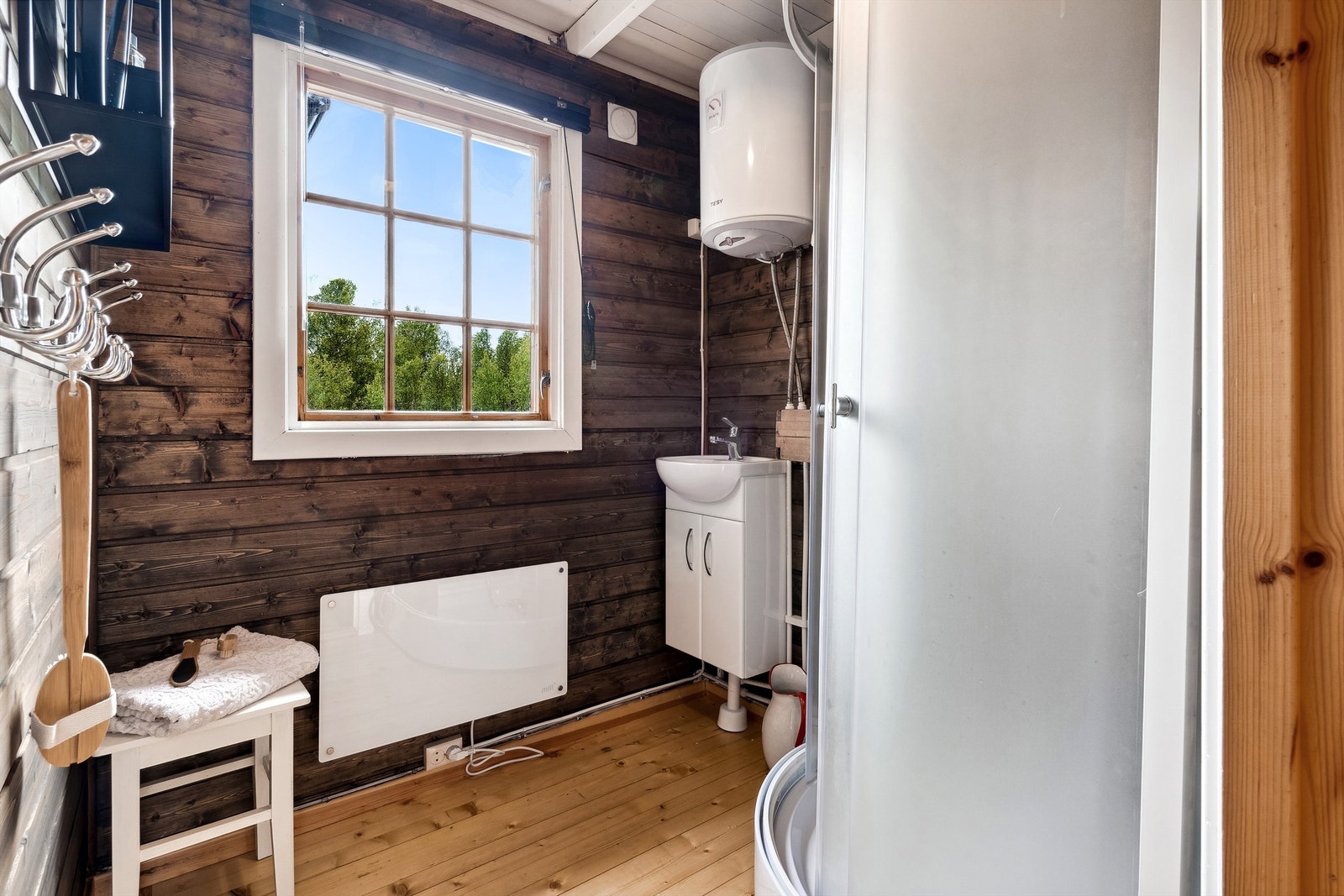 Badet er utstyrt med et dusjkabinett og en liten vask på underskap. Her er det også montert en liten varmtvannsbereder for en kort dusj etter skituren. Galleribilde