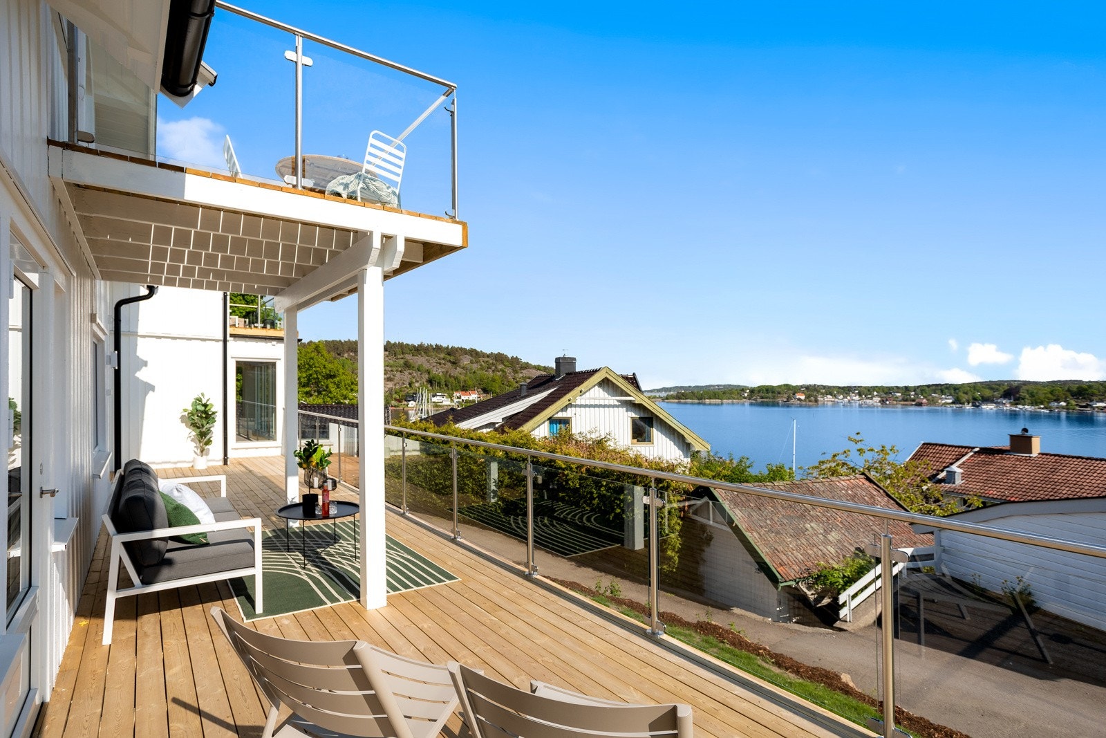 Nybygget terrasse med nytt glassrekkverk i syrefast. Adkomst både fra kjøkken og stue, samt direkte fra hagen. Galleribilde