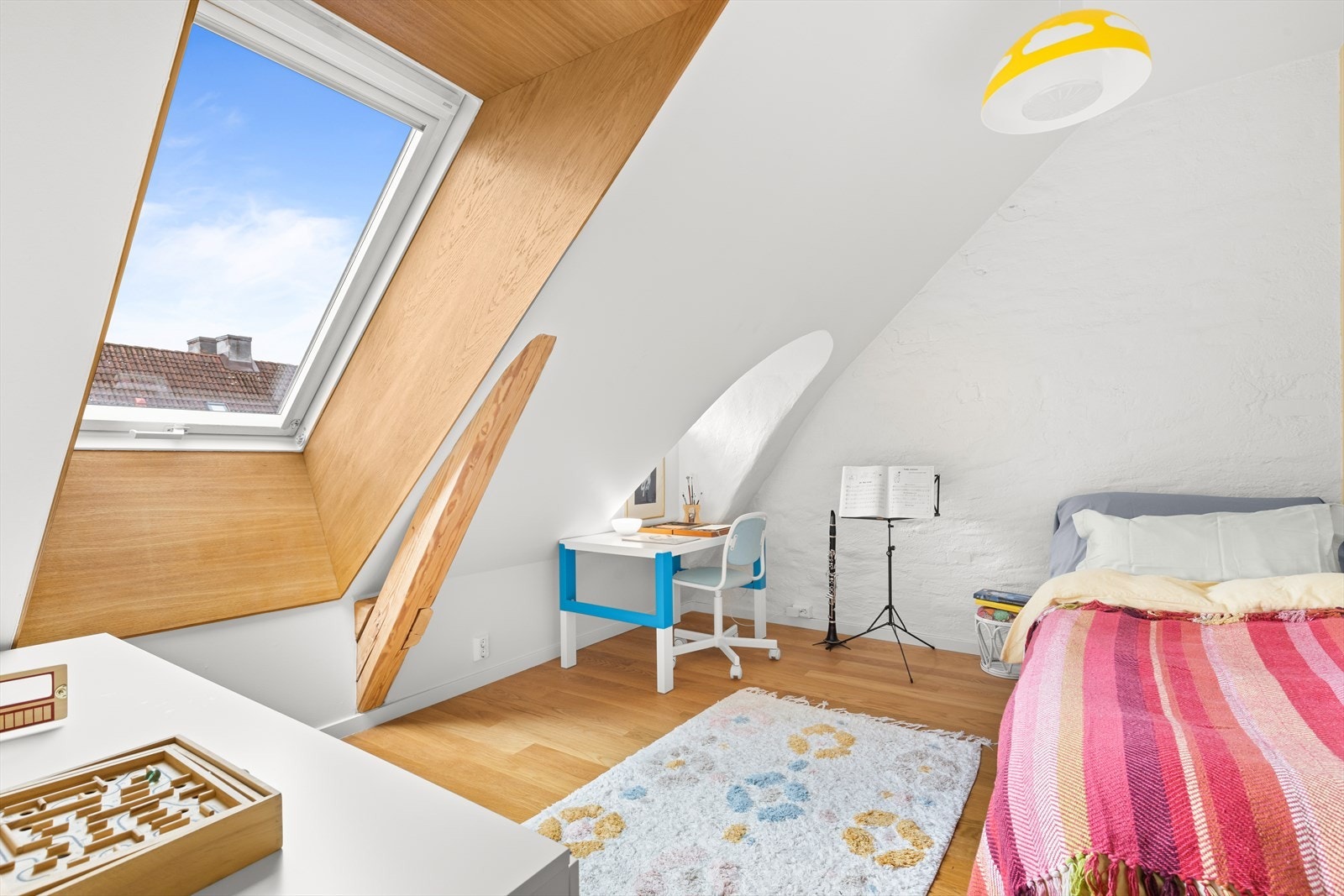 Her fra et av barnerommene. Her er det plass til dobbeltseng om ønskelig. Leilighetens takvinduer har skråstilte vinduskarmer for optimalt lysinnslipp. Dette er Veluxvinduer med ventilasjonsmulighet. I tillegg har rommet en liten original vindusark. Galleribilde