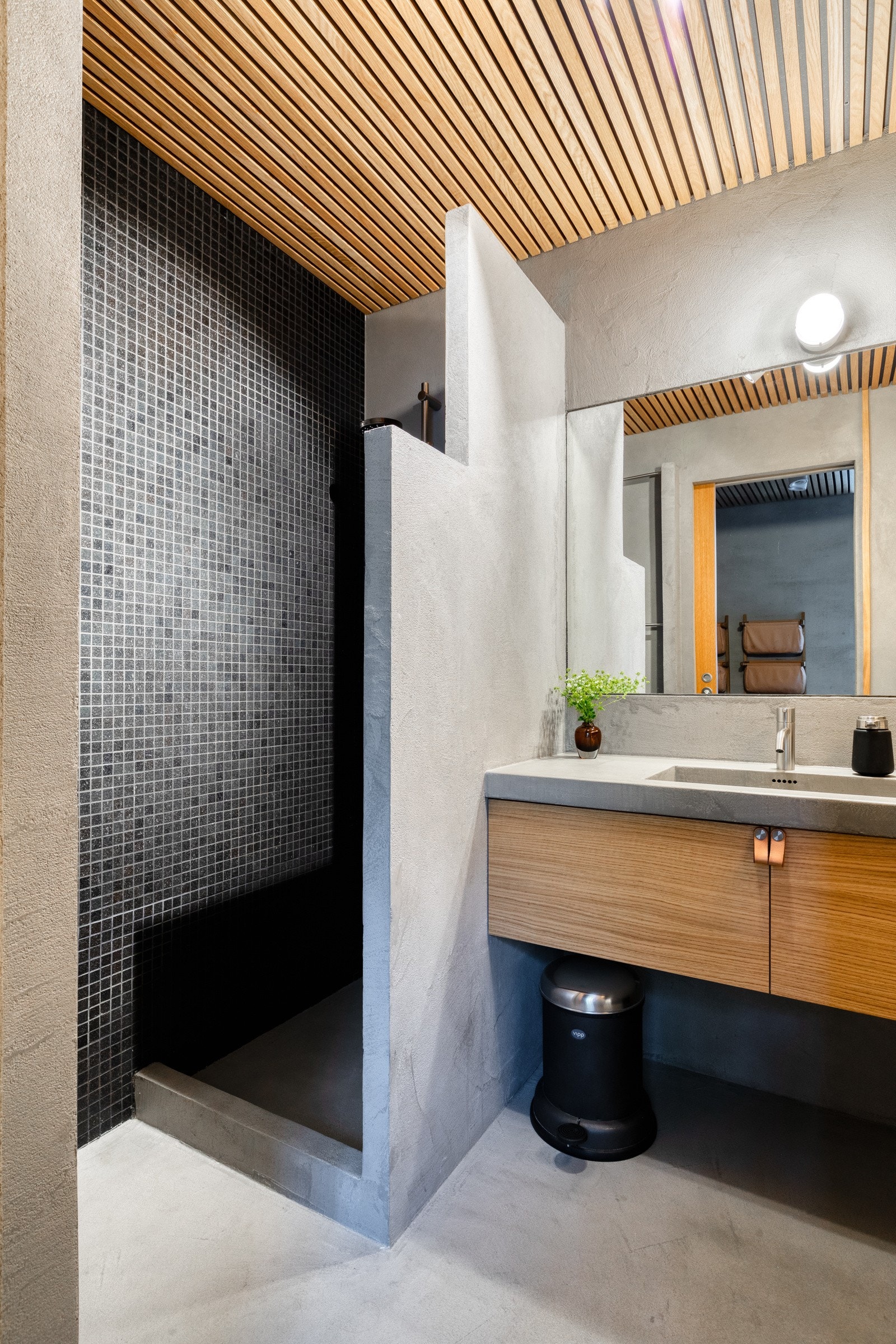 Badet har dusjnisje med oppbevaringsplass for såper / sjampo, toalett og speil over servantinnredning med overlys. Galleribilde