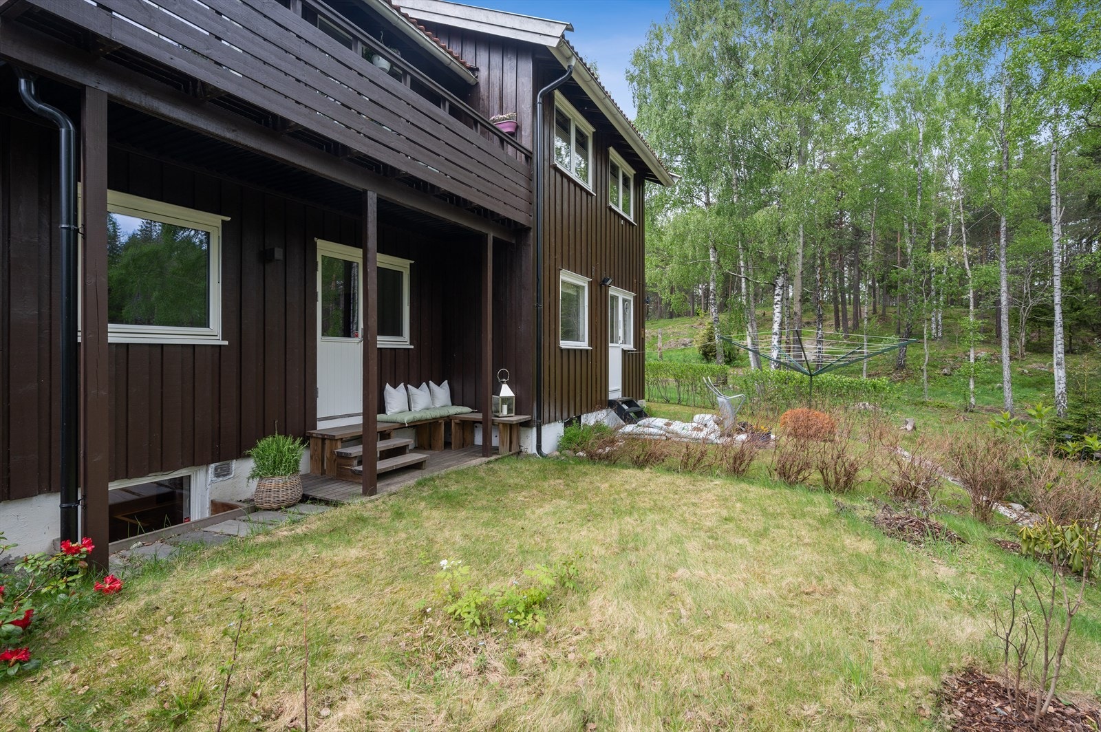 Én av flere flotte uteplasser tilhørende boligen. Her med liten platting og grøntarealer på baksiden av huset. Galleribilde