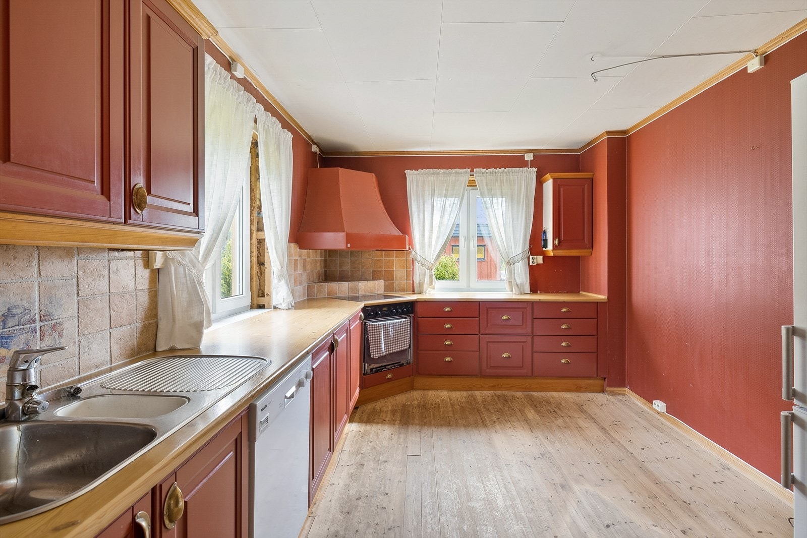 Kjøkkenet har innredning med profilerte fronter. Benkeplaten er av laminat. Det er avtrekk over kokesone. Galleribilde