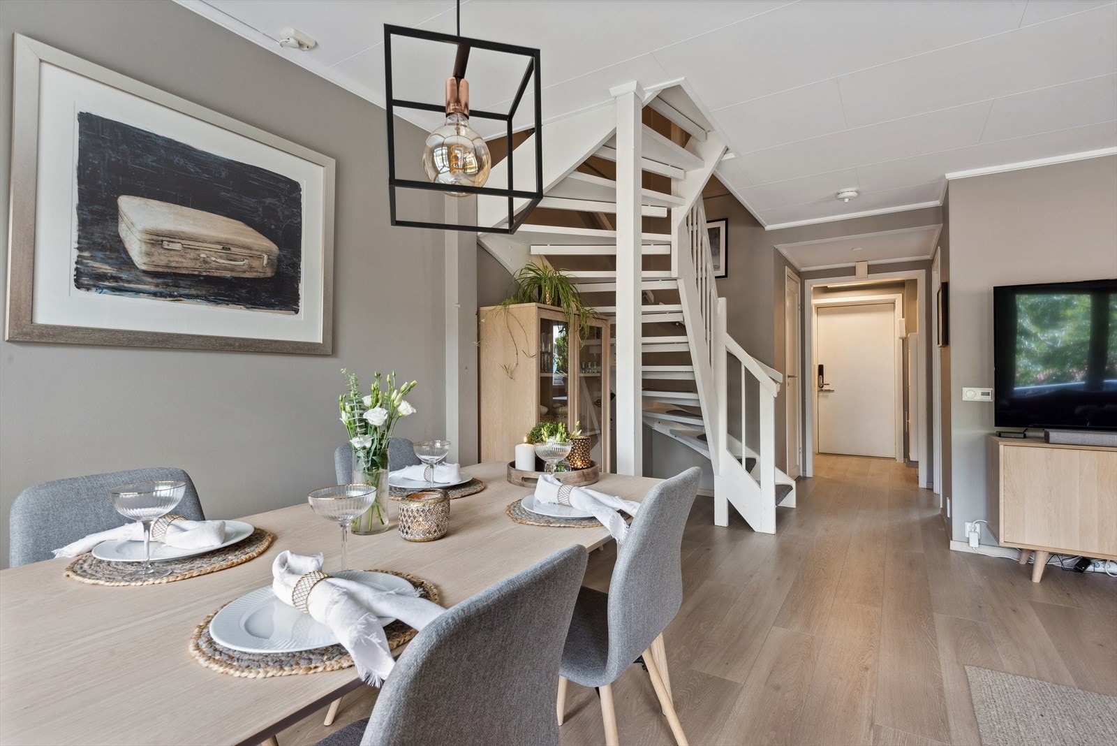 Veggene i stuen er glatte, malt i en lys tone og gulvet er laminat fra 2022 med varmefolie. Galleribilde