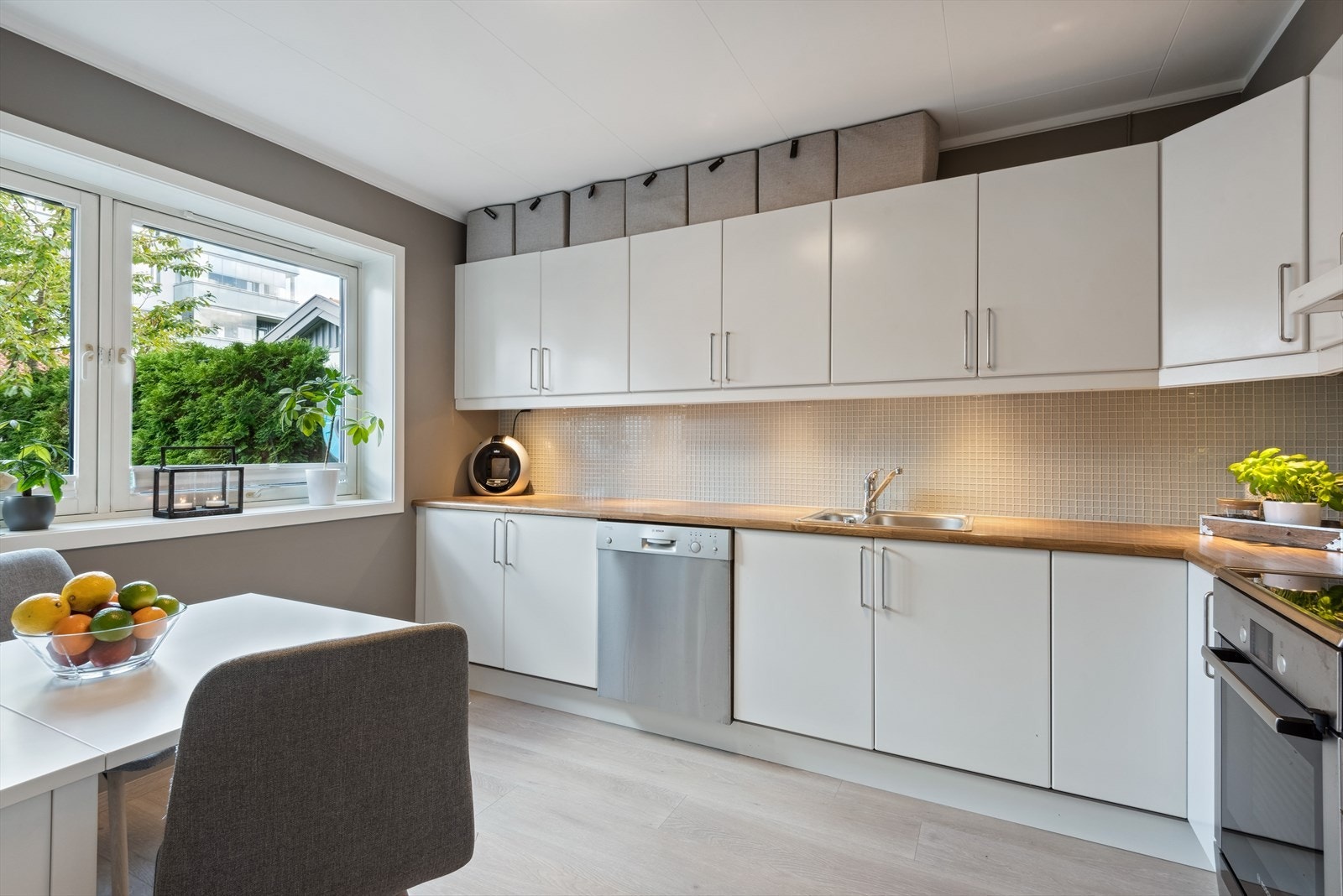 Kjøkkeninnredningen har glatte, lyse fronter fra byggeår med laminert benkeplate. Galleribilde