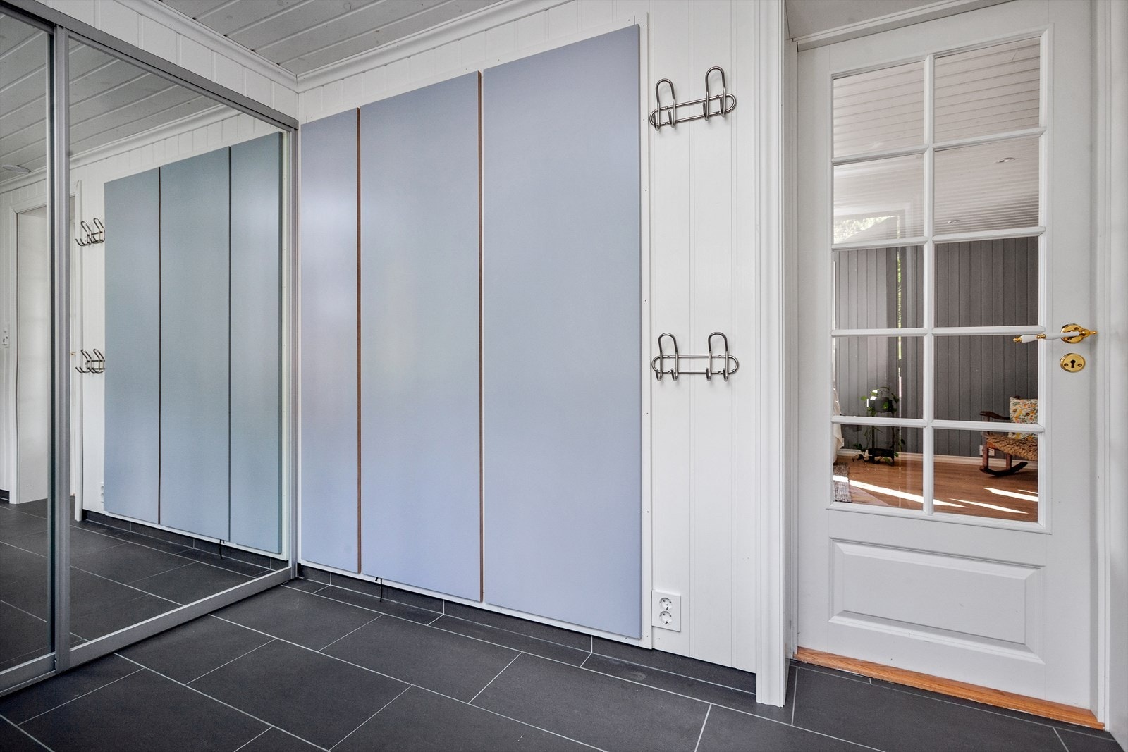 Det er stor skyvedørsgarderobe med speildører og integrerte garderobeskap i veggen mot stuen. Det romslige vaskerommet er også utstyrt med arbeidsbenk med nedfelt rustfri kum, skapinnredning, bereder, opplegg for vaskemaskin. Galleribilde