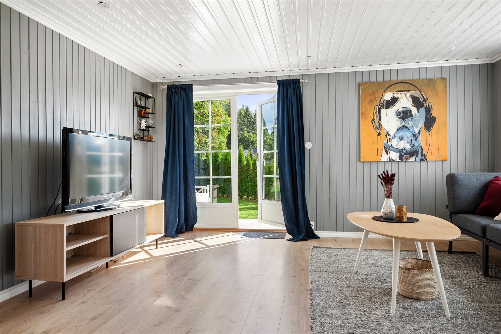 Fra TV-stuen er det en dobbelfølyet glassdør som leder ut til en stor terrasse. Galleribilde