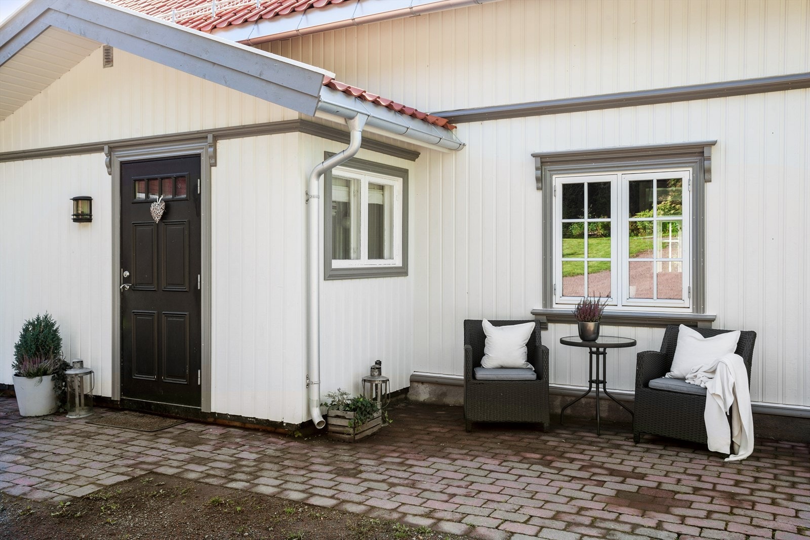 Inngangspartiet er er brosteinsbelagt, er overbygget og har direkte adkomst fra gårdsplassen. Ved entrédøren er det en koselig uteplass med plass til ønsket møblement. Galleribilde