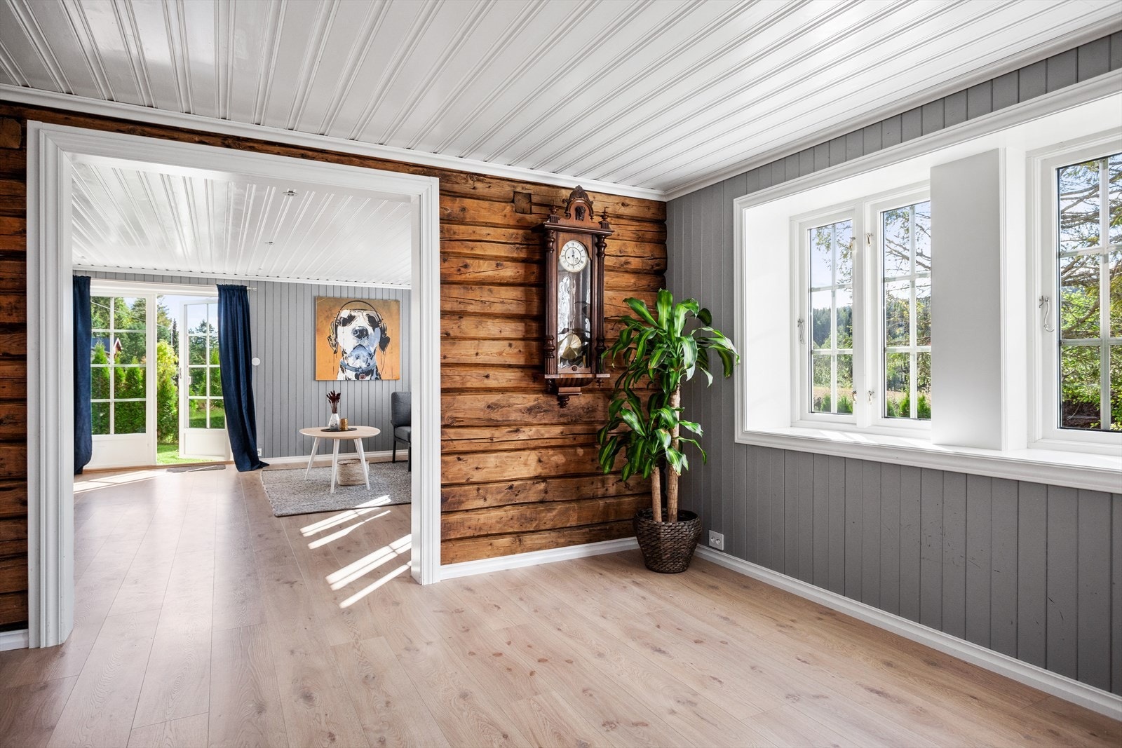 Stuen henger sammen med en ny stue og disse stuene er naturlig delt fra hverandre med en tømmervegg. Det er gode vindusflater i begge stuene slik at rikelig med naturlig lys finner veien inn i boligen. Galleribilde