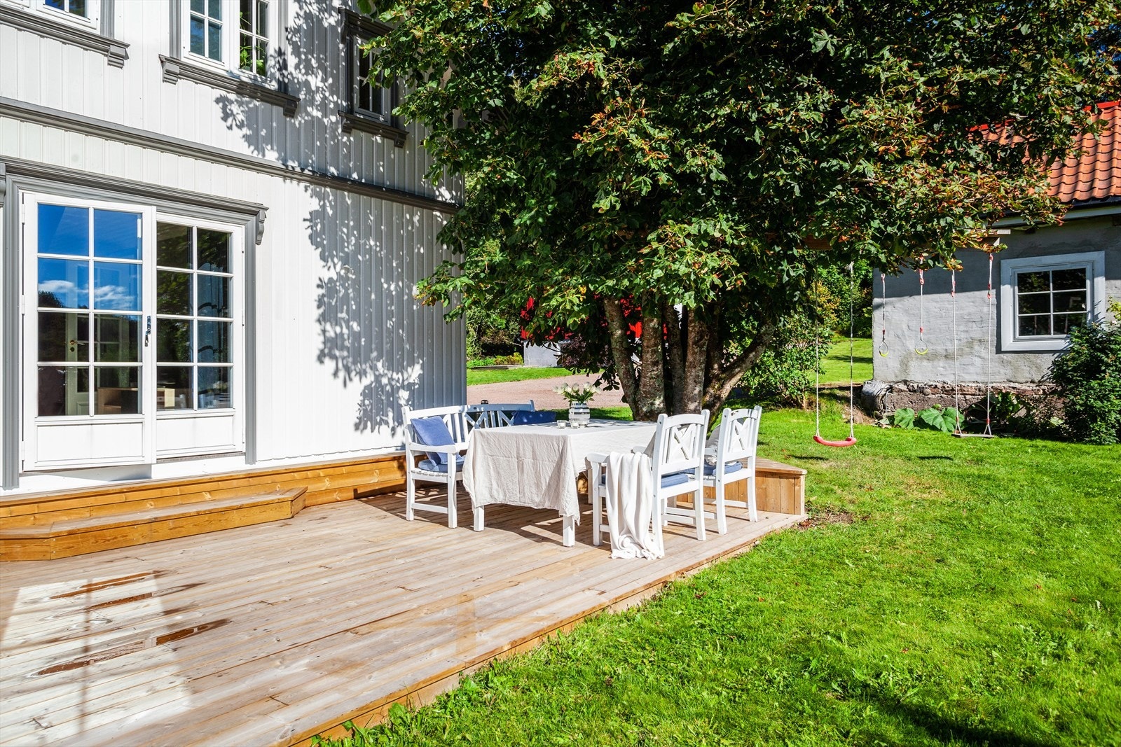 Det er utgang til en stor solrik terrasse som strekker seg rundt hele den sydlige enden av huset. Galleribilde