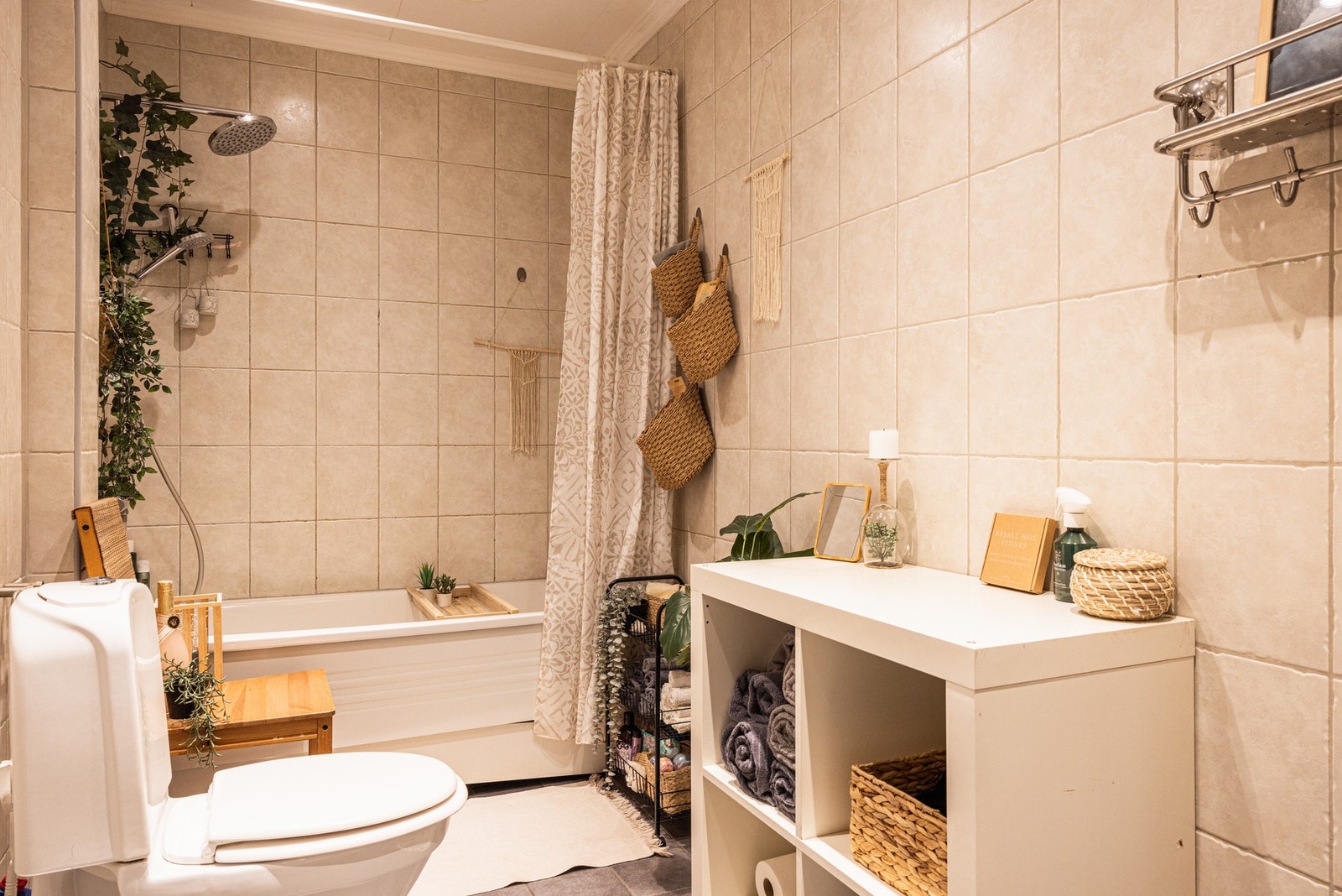 Baderom med lyse fliser og hvite baderomsmøbler. Galleribilde