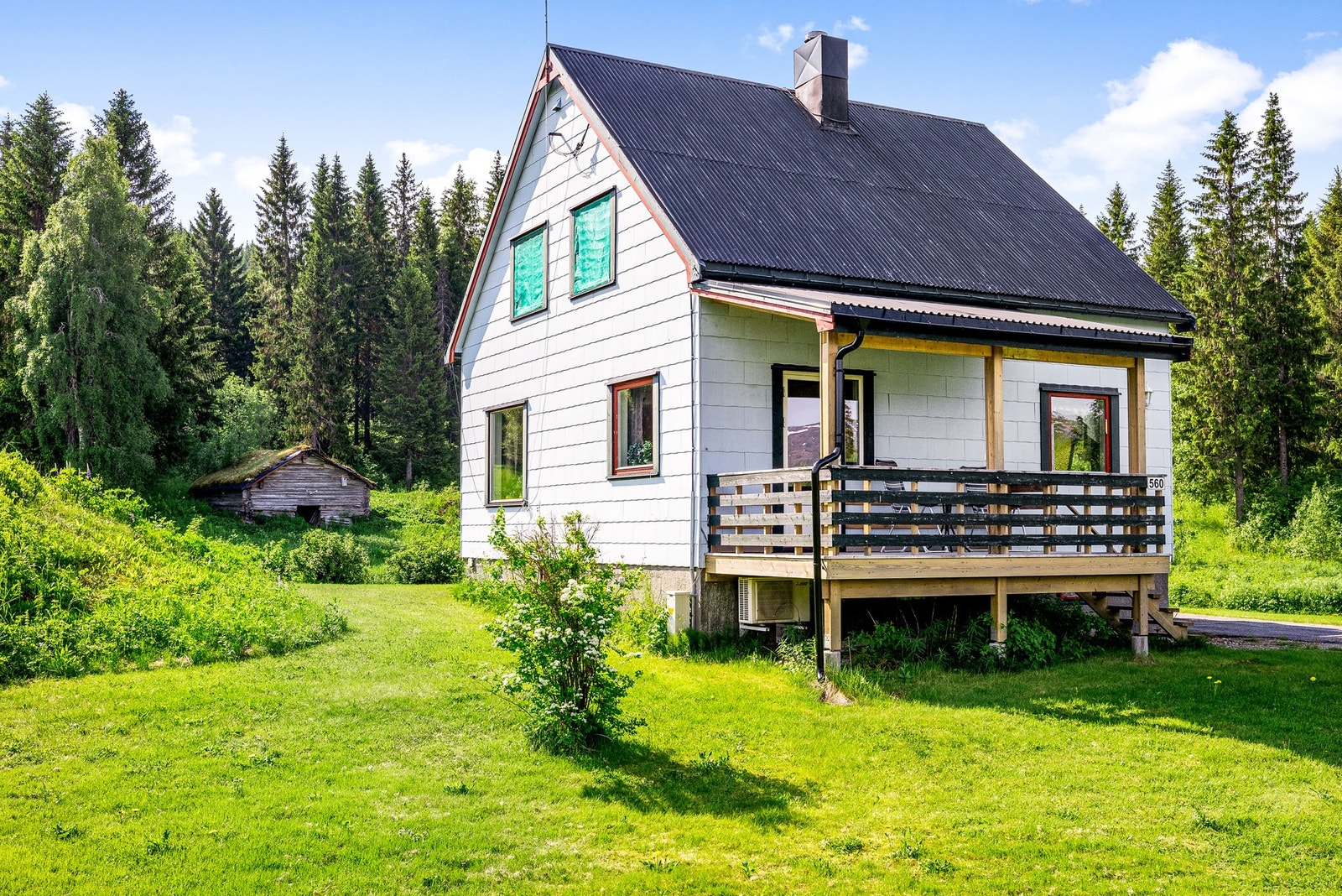 Romslig og tilnærmet flat tomt. Enkel opparbeidet hage med plen og diverse beplantning Galleribilde