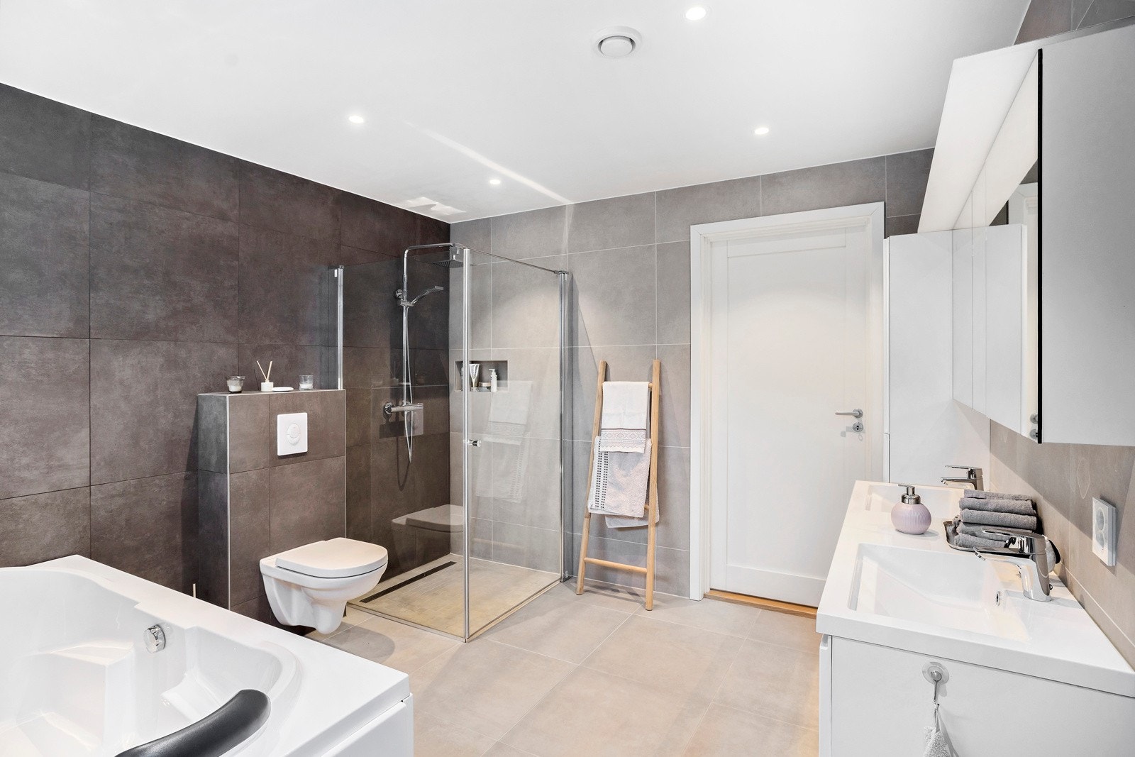 Badet er innredet med badekar, vegghengt toalett og dusjhjørne. Innredningen er av merket Foss Galleribilde