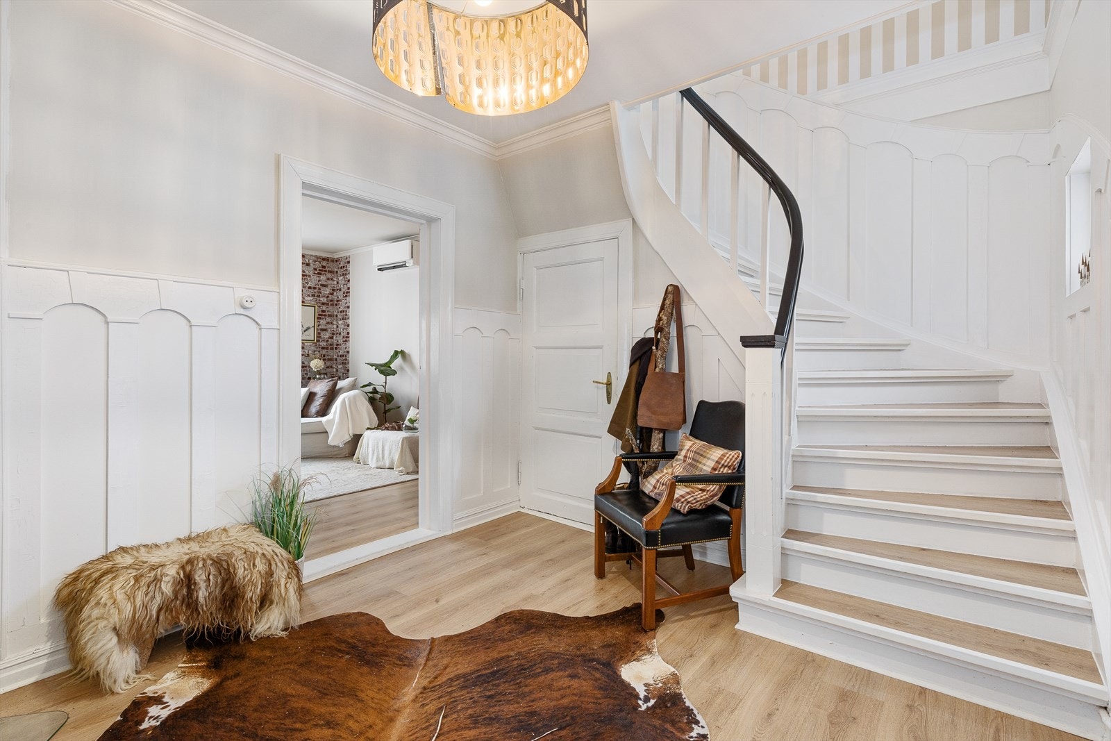 Hallen er stor og innbydende med klassisk trapp og hvitmalte dekorlister på veggene. Galleribilde