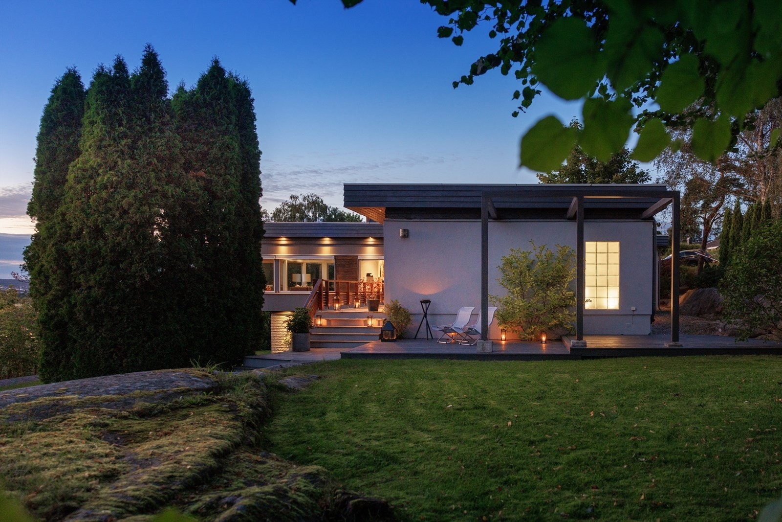 Eiendommen har en nydelig, frodig hage innrammet av svaberg og løvtrær - en skjermet oase med flotte uteplasser. Galleribilde