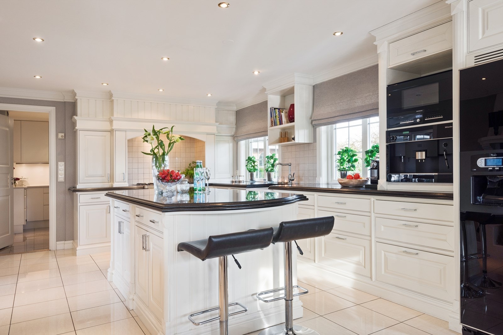 Eneboligen har et herskapelig kjøkken med storslått kjøkkenøy, peis med innsats og god plass for spisebord, noe som gjør rommet til et perfekt knutepunkt for familien. Galleribilde