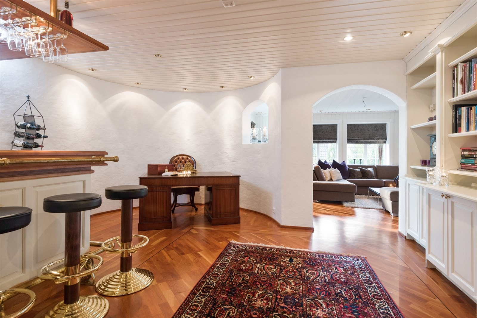 Fra kjellerstuen er det åpen løsning inn til et stilfullt bibliotek med spesialbygde bokhyller og skap. I tillegg er har rommet en fastmontert barløsning med vask. Galleribilde