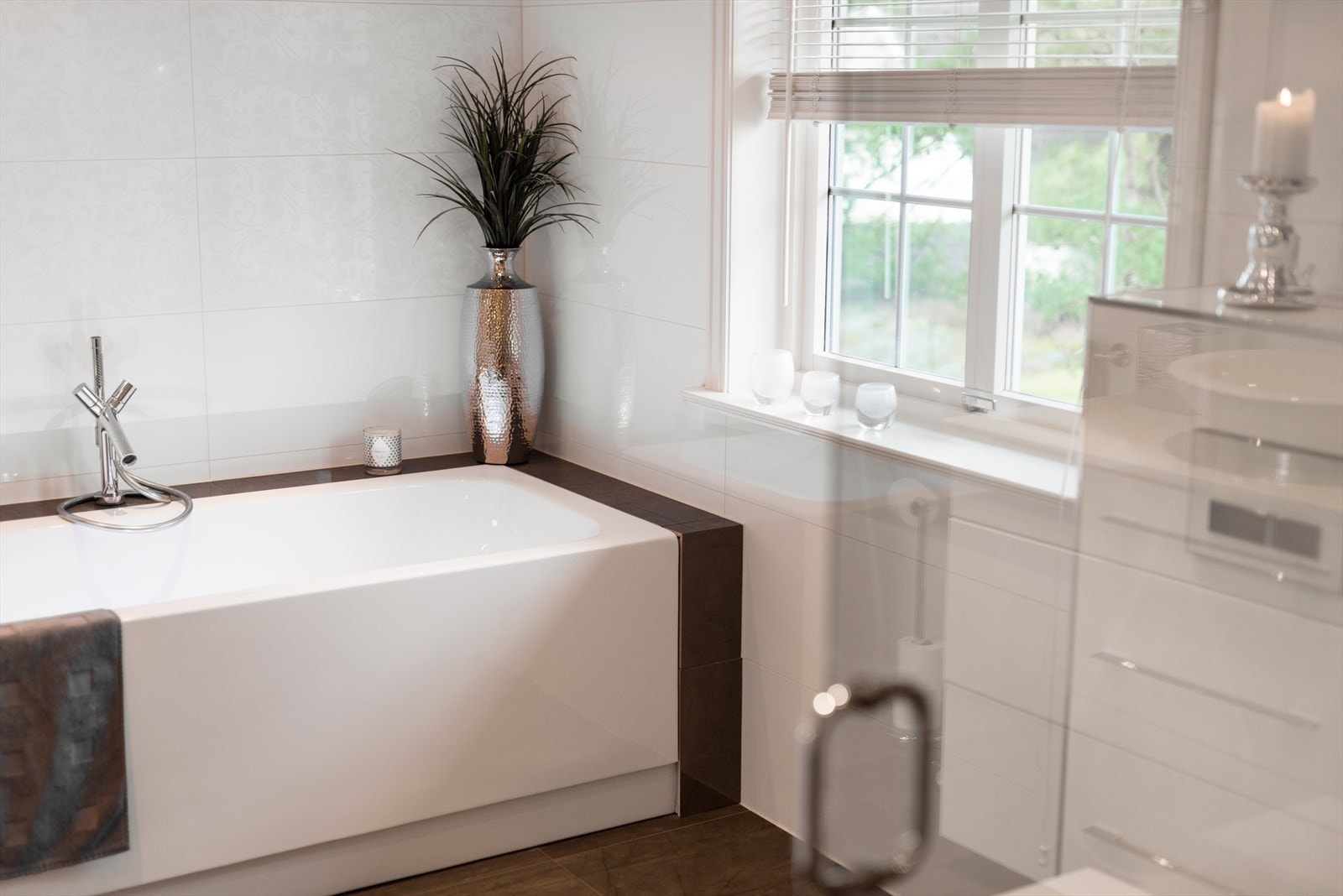 Rommet har stort dusjhjørne med to regnfallsdusjer og et badekar med terapilys. Galleribilde