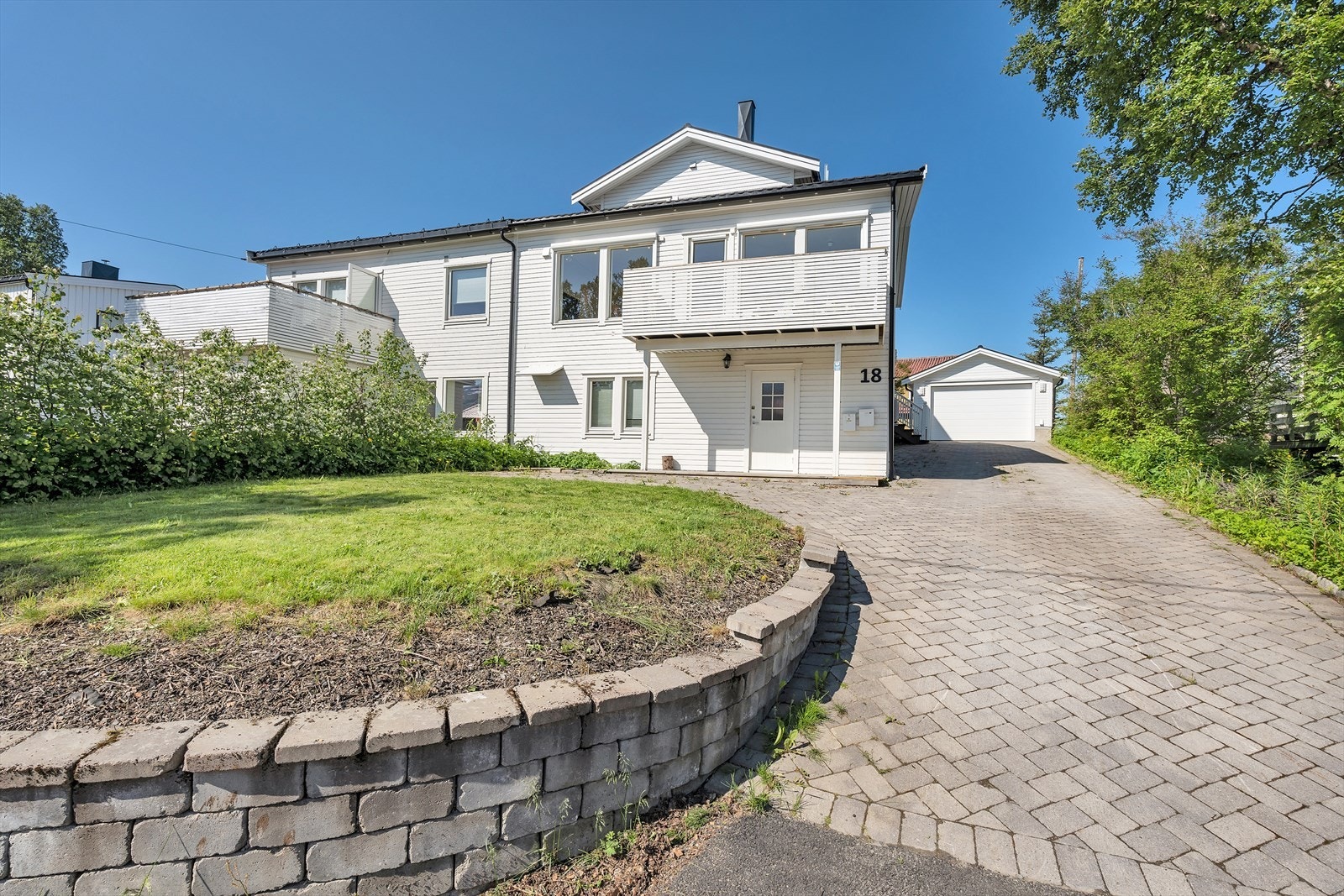 Tomten er pent opparbeidet med plen og noe beplantet. Galleribilde