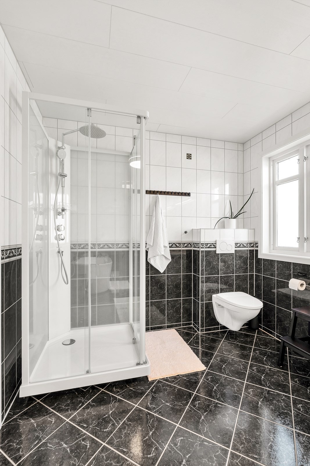 Badet har dusjkabinett og badekar. Galleribilde