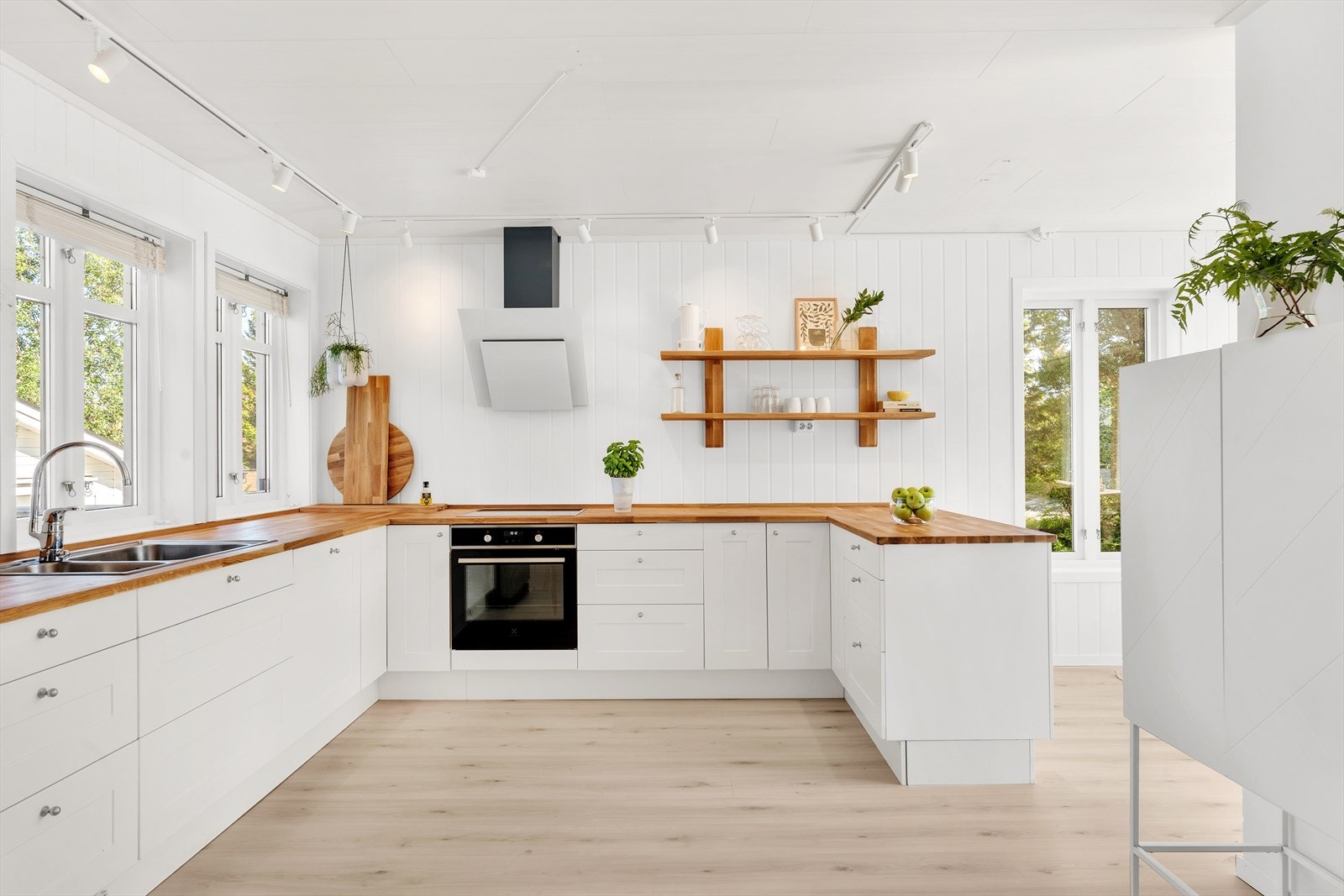 Kjøkken med rikelig skap -og benkeplass. Galleribilde