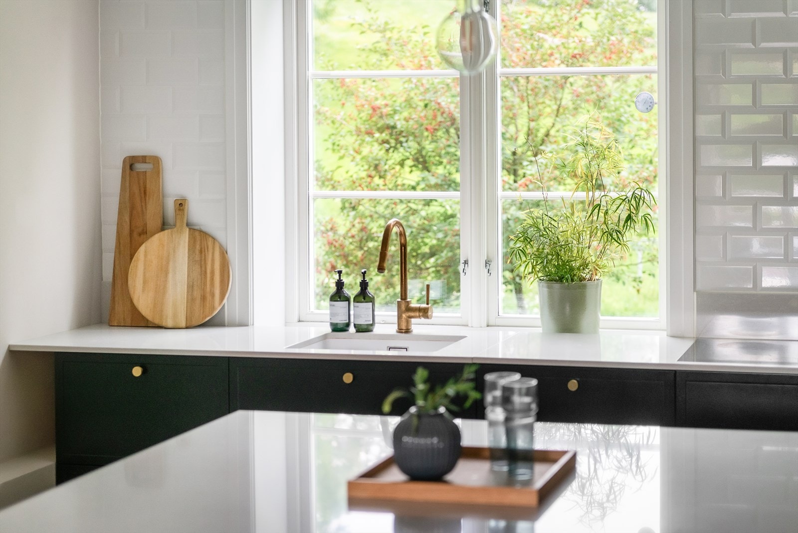 Flotte og gjennomtenkte detaljer med kompositt benkeplate samt. uttrekkbart messing armatur fra Tapwell og knotter i messing. Galleribilde