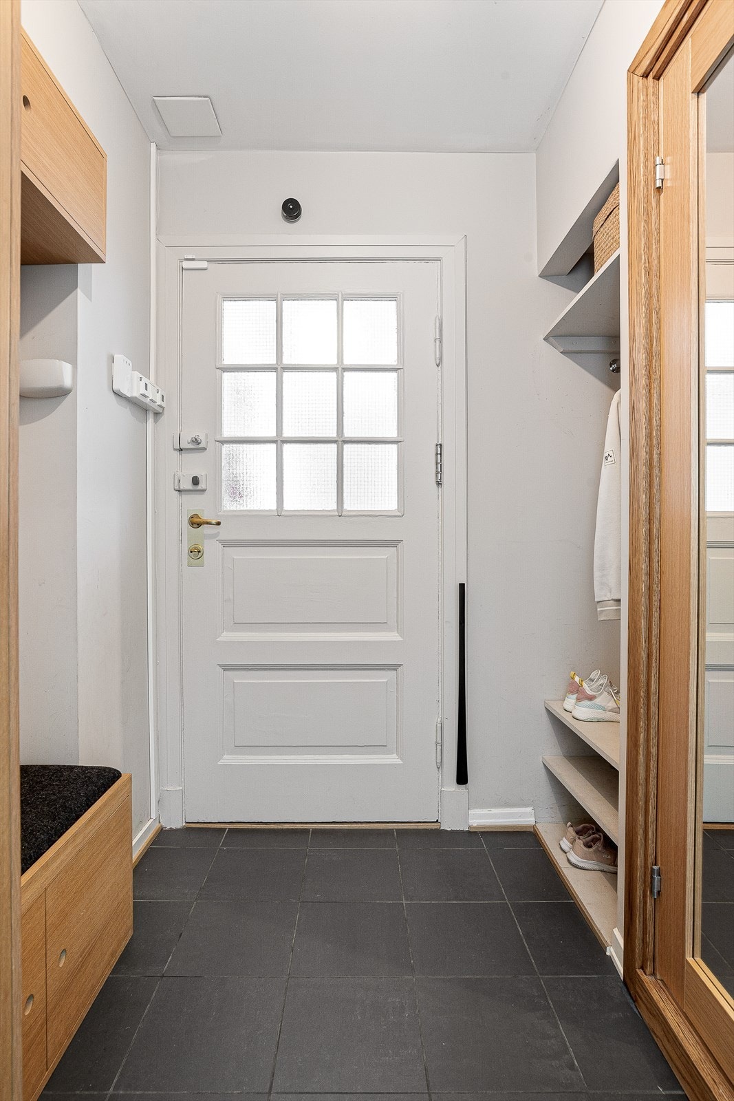 Flislagt entré med god oppbevaring. Plassbygd skap- og benkeløsning i eik Galleribilde