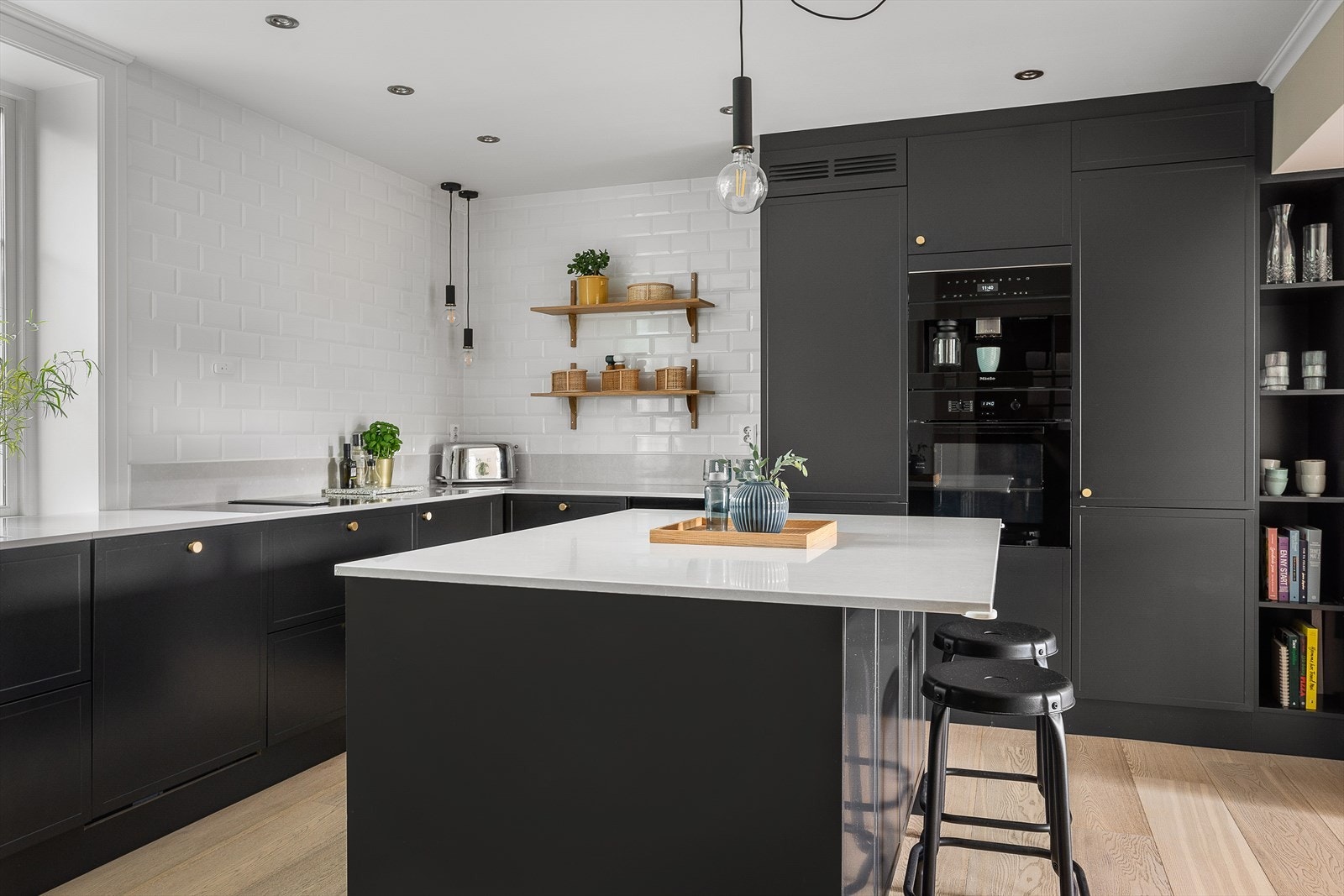 Hyggelig sitteplass på praktisk kjøkkenøy. Integrert kaffemaskin, stekeovn og platetopp med ventilator fra Miele. Galleribilde