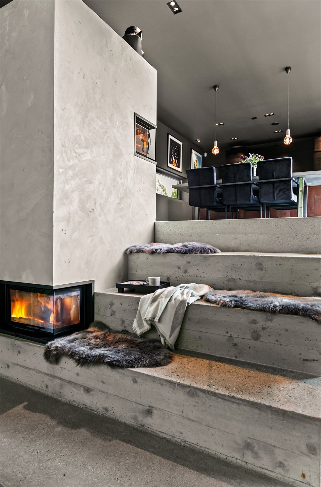 Eiendommen har utstrakt bruk av betong, her i en flott trappeløsning opp mot kjøkkenet, som også fungerer som sitteplasser Galleribilde