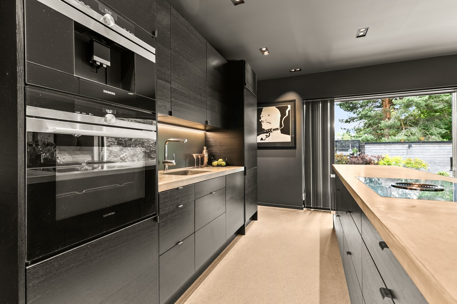Kjøkkenet har en flott innredning i sort med integrerte hvitevarer fra Siemens Galleribilde