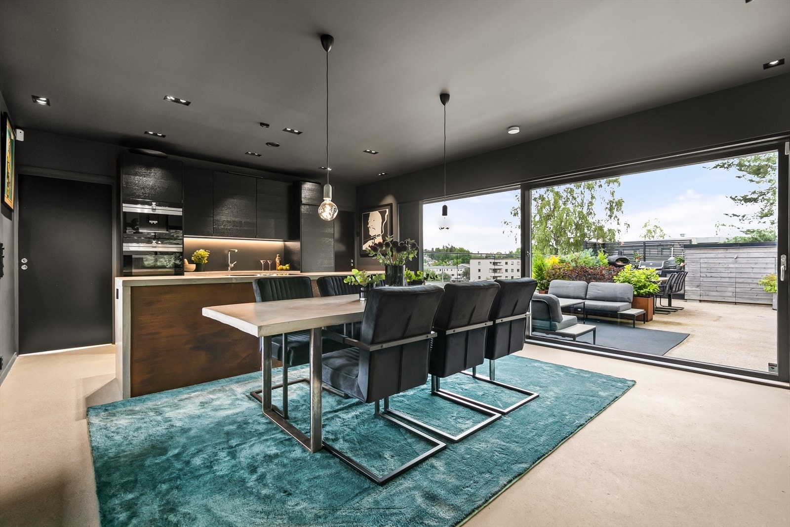 Fra kjøkkensonen er det et stort skyvefelt ut mot terrassen, der det er flere sittegrupper, samt et utekjøkken Galleribilde