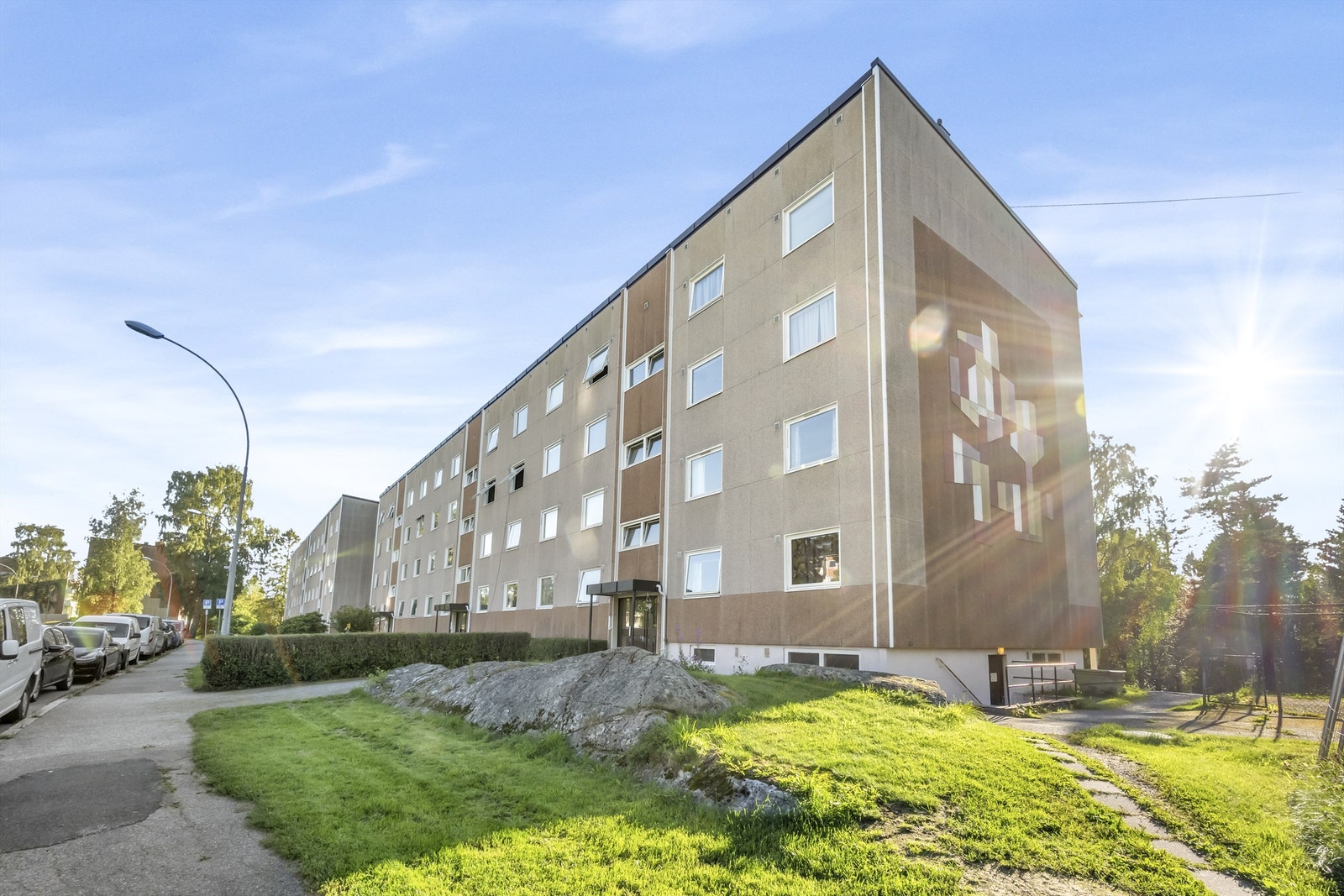 Leiligheten ligger usjenert til på enden av blokka i 3. etasje. Mye grønt og frodig omkranser blokkene. Galleribilde