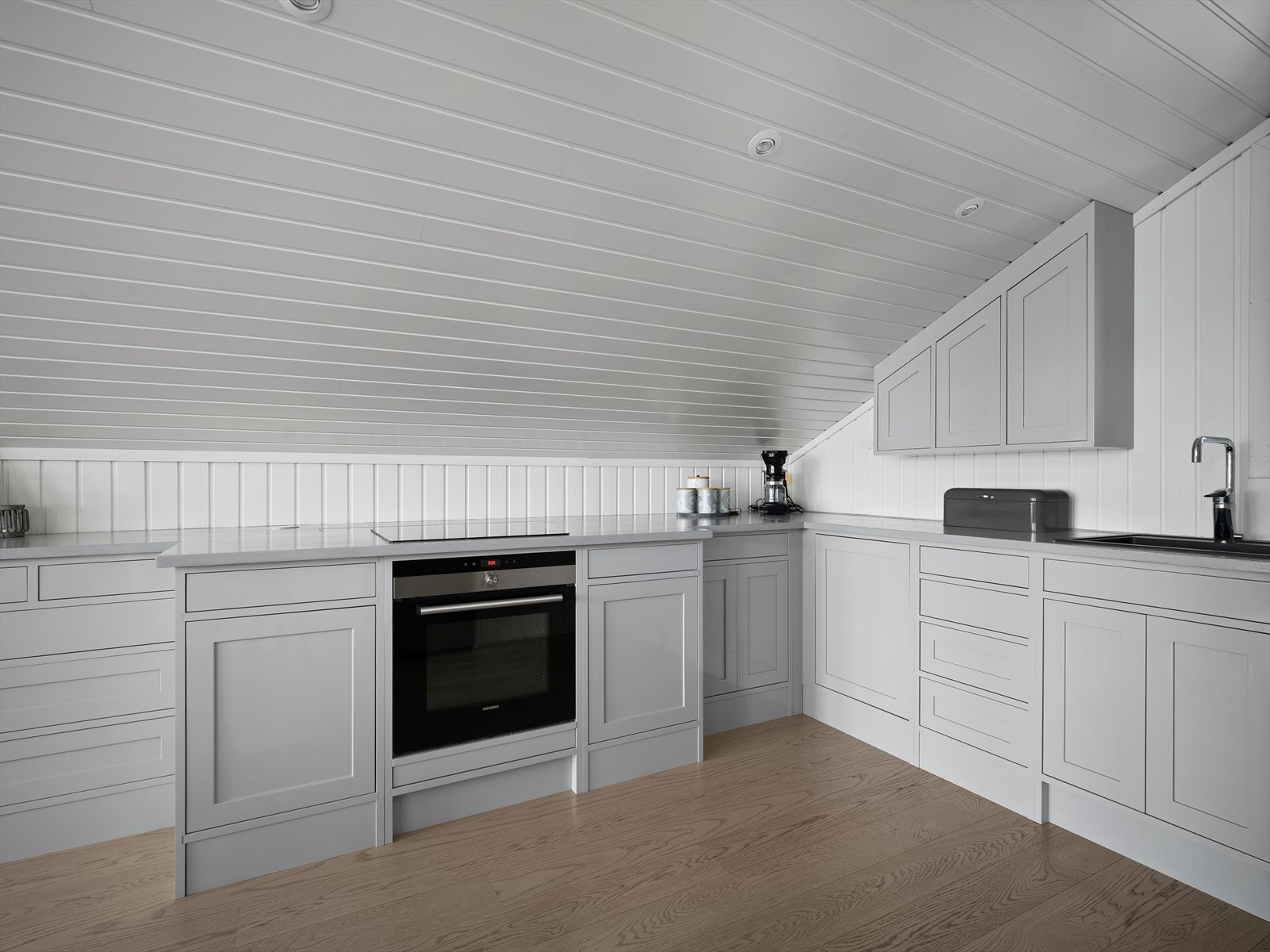 Innredningen har profilerte fronter, nisje for kjøleskap samt en heltre benkeplate med nedfelt oppvaskkum i kompositt og ventilator med uttrekk. Galleribilde