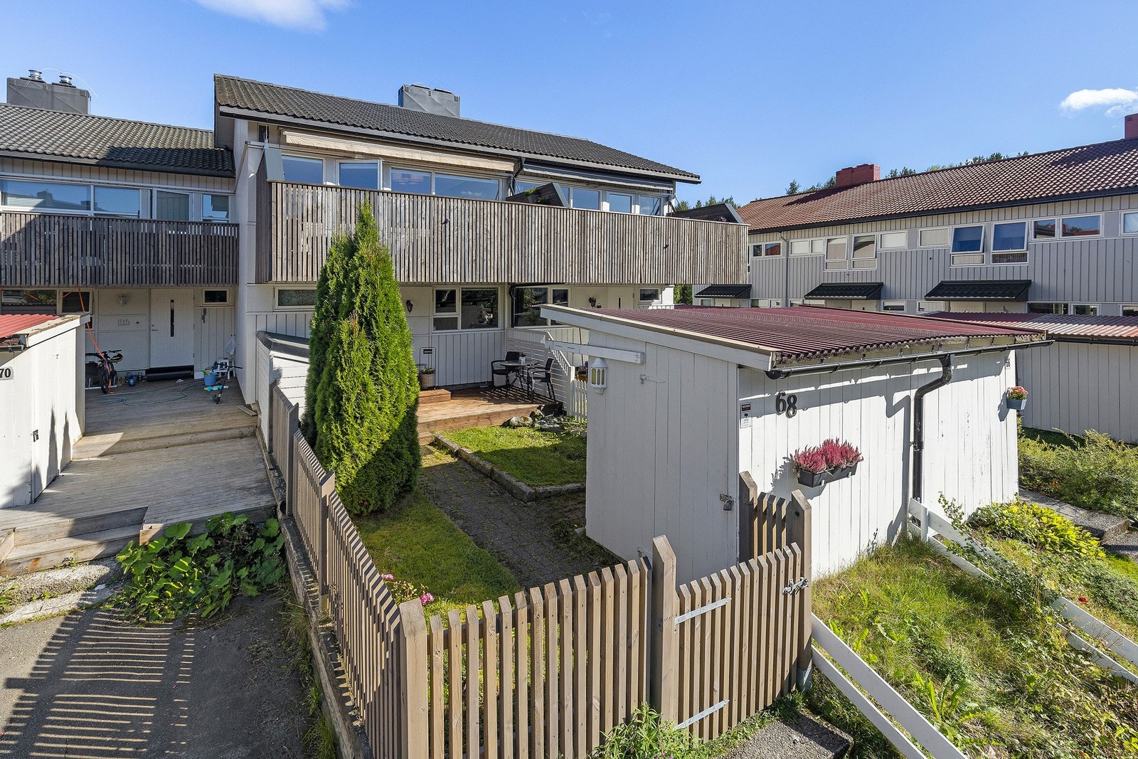 Rekkehuset har en pen liten hage og en praktisk sportsbod like ved inngangen. Galleribilde