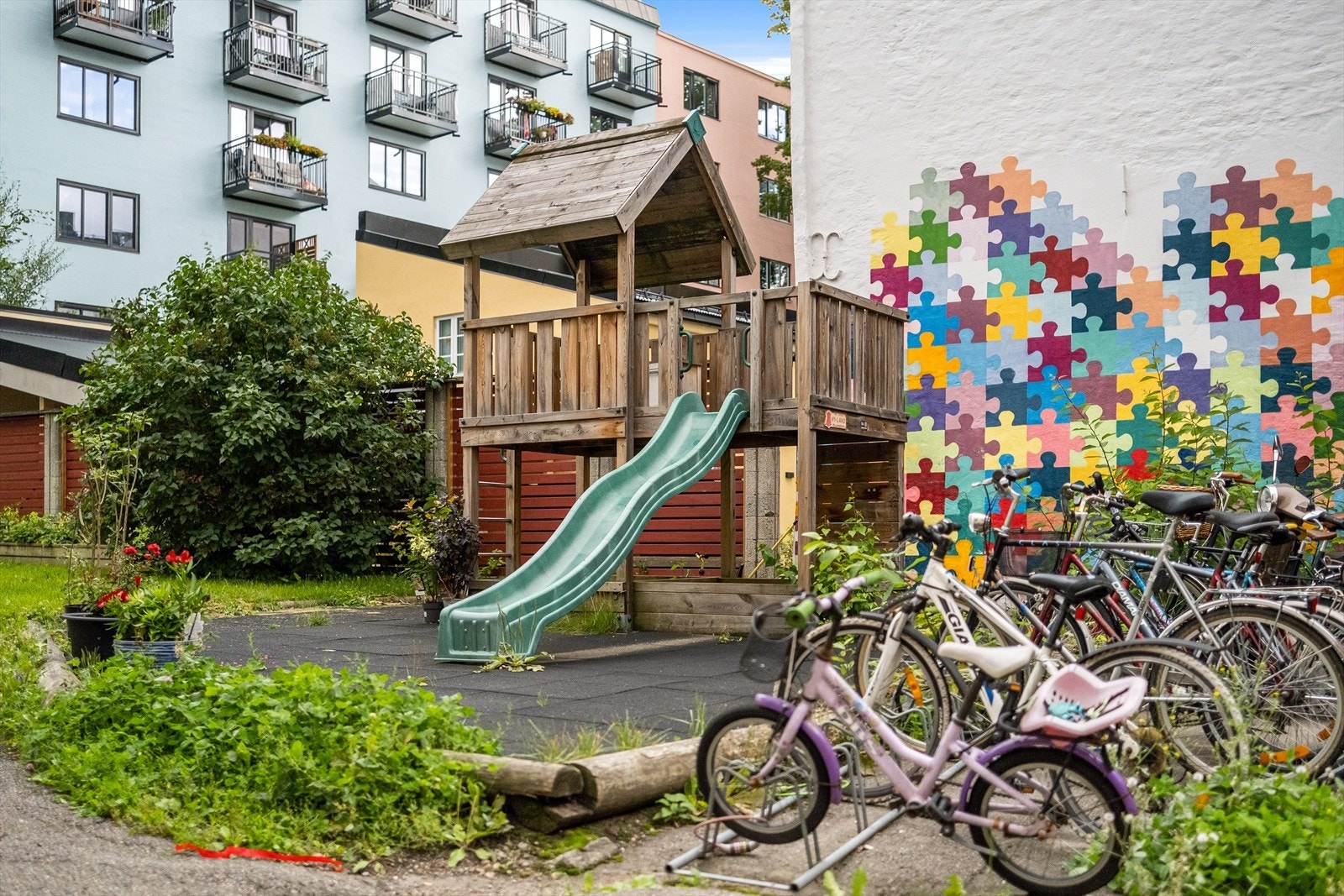 Det er lekeapparat med sklie for de minste og sykkelparkering Galleribilde