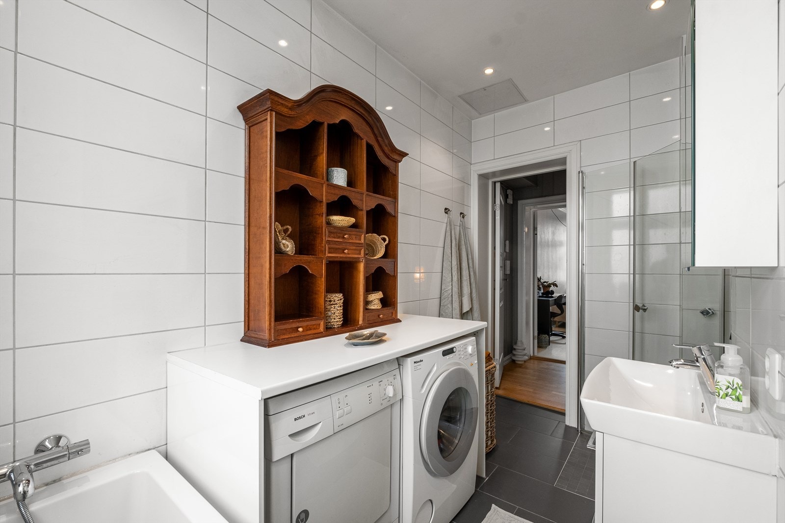 Badet har elektrisk vifte og opplegg for vaskemaskin og tørketrommel Galleribilde