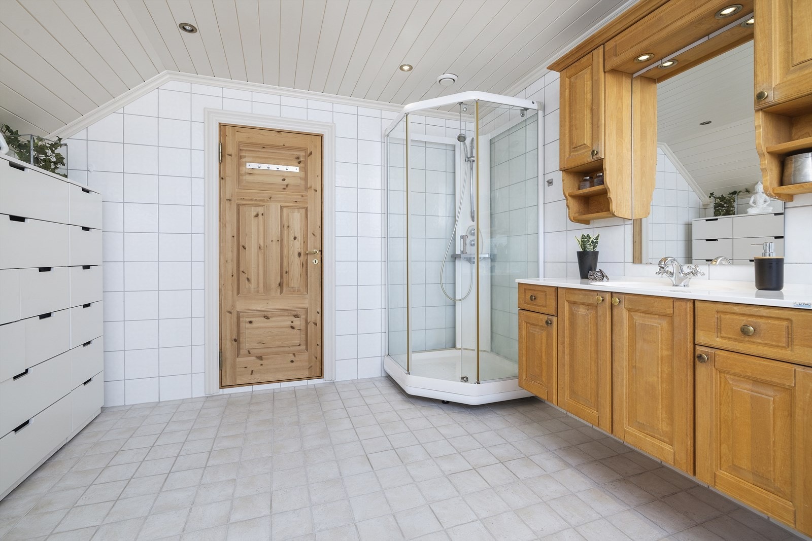 Badet har fliser på gulv og vegger, panel i tak. Galleribilde