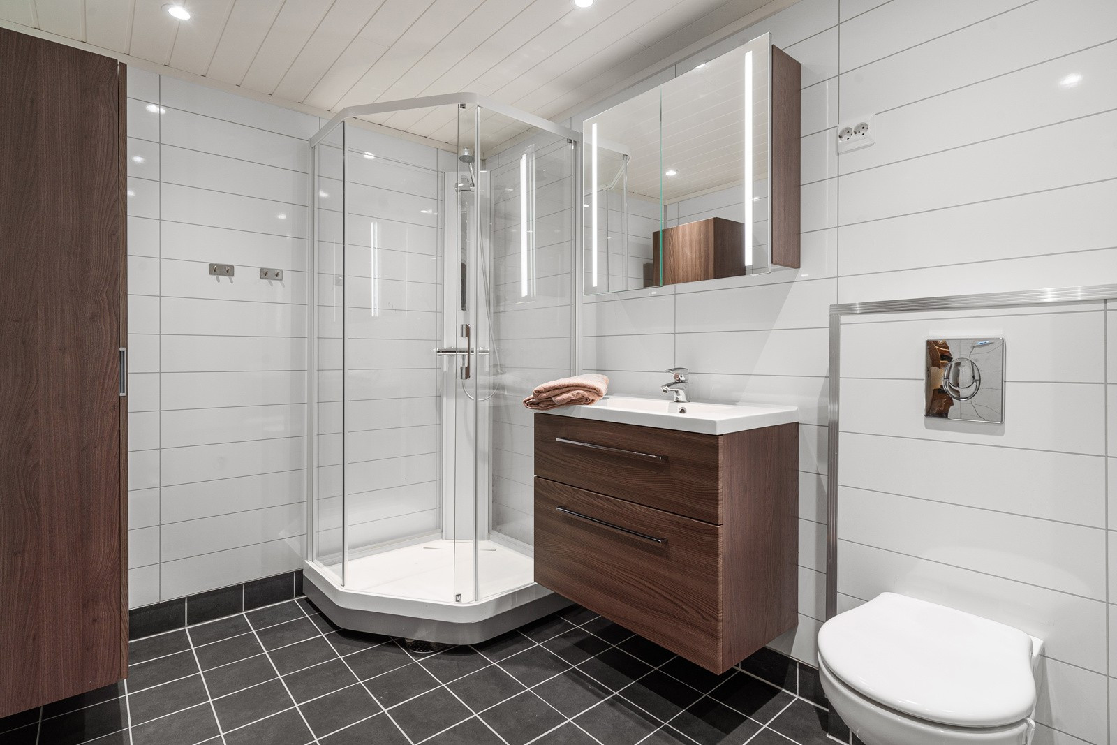 Badet har lyse tidsriktige våtromsplater og flislagt gulv.