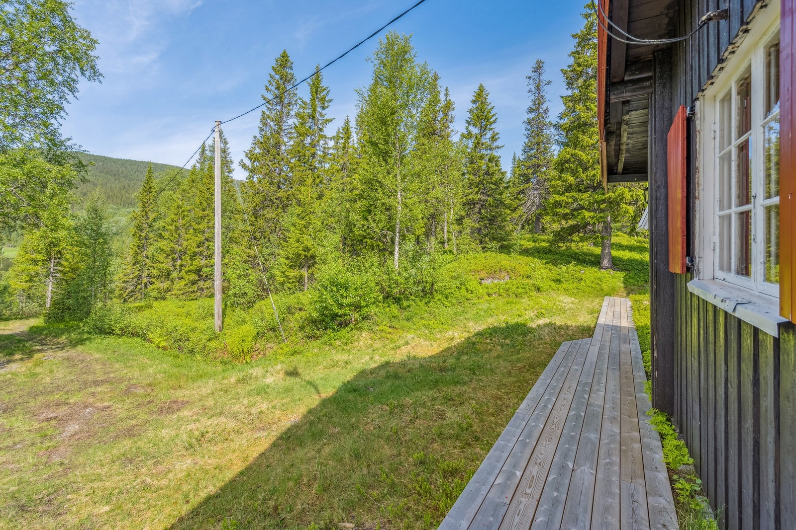 På sommerstid kan man enkelt kjøre helt frem til hytta og parkere på gresset ved plattingen. Galleribilde