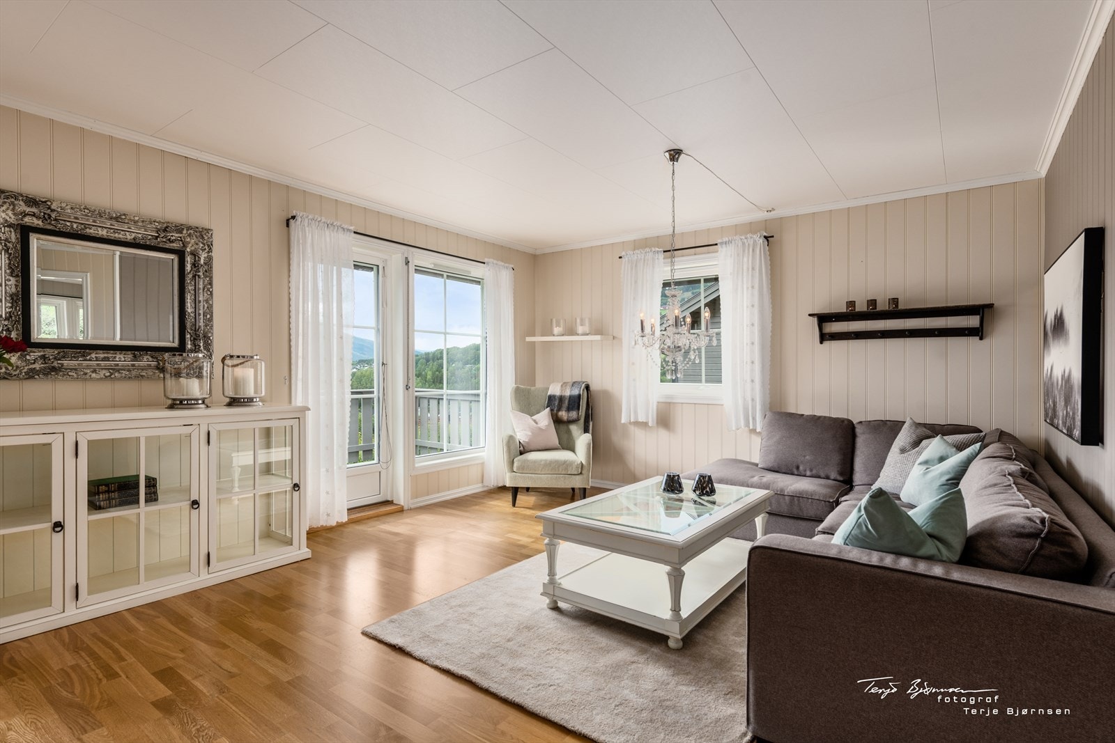 Lyse flater og store vinduer med godt lysinnslipp møter deg i denne lune stuen. Galleribilde