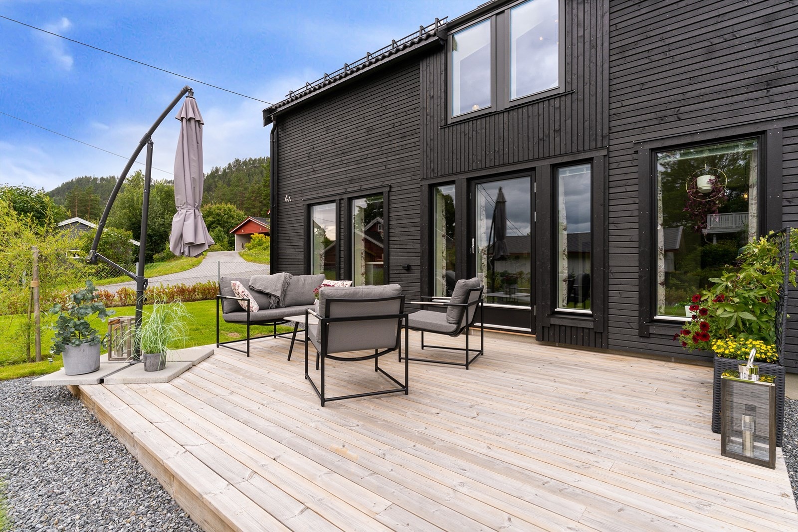 Uteplass med rom for å kunne ha sittegruppe og spisegruppe, parasol og beplantning. Galleribilde