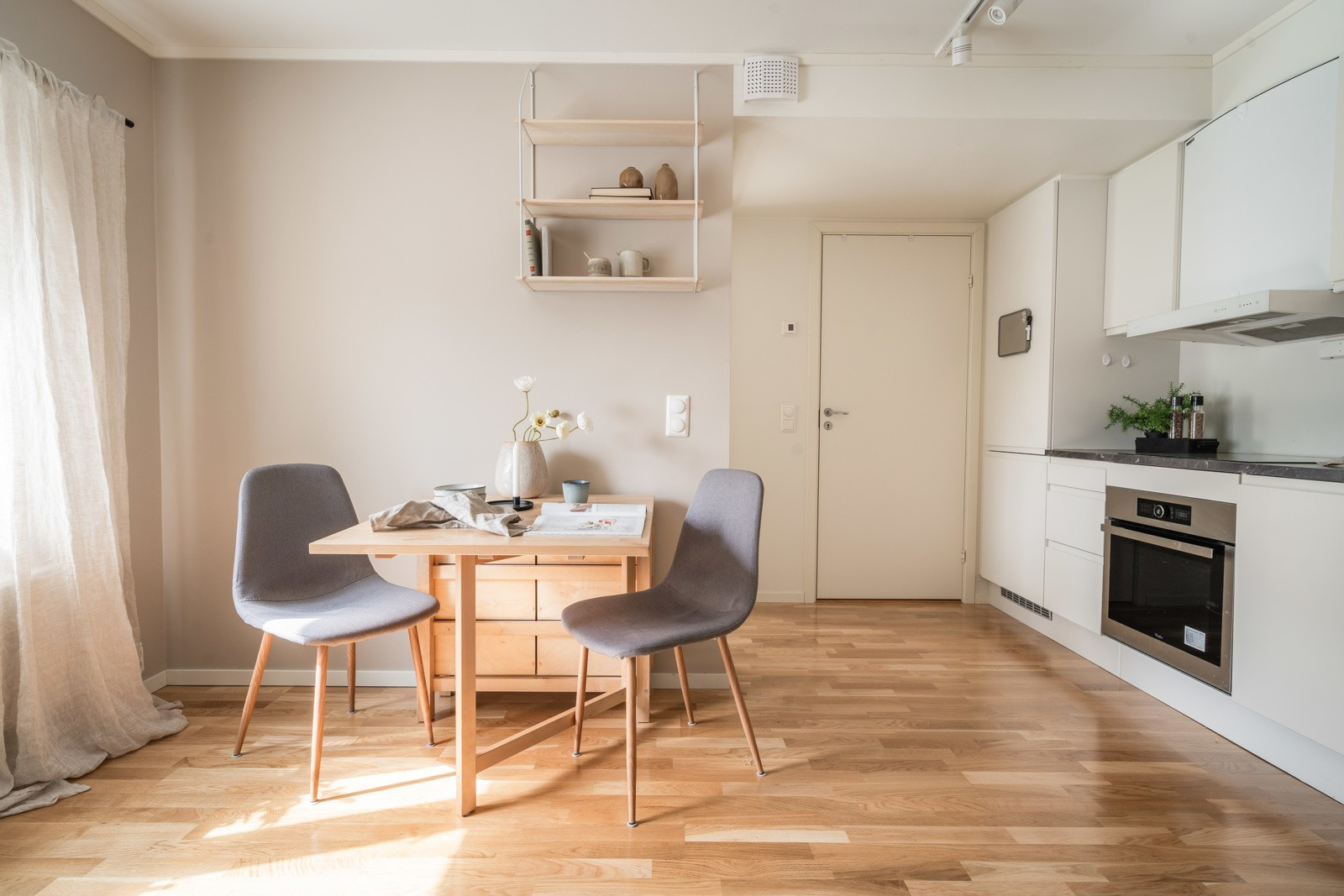 Åpen stue- og kjøkkenløsning med plass til spisebord i tilknytning til kjøkkenet.